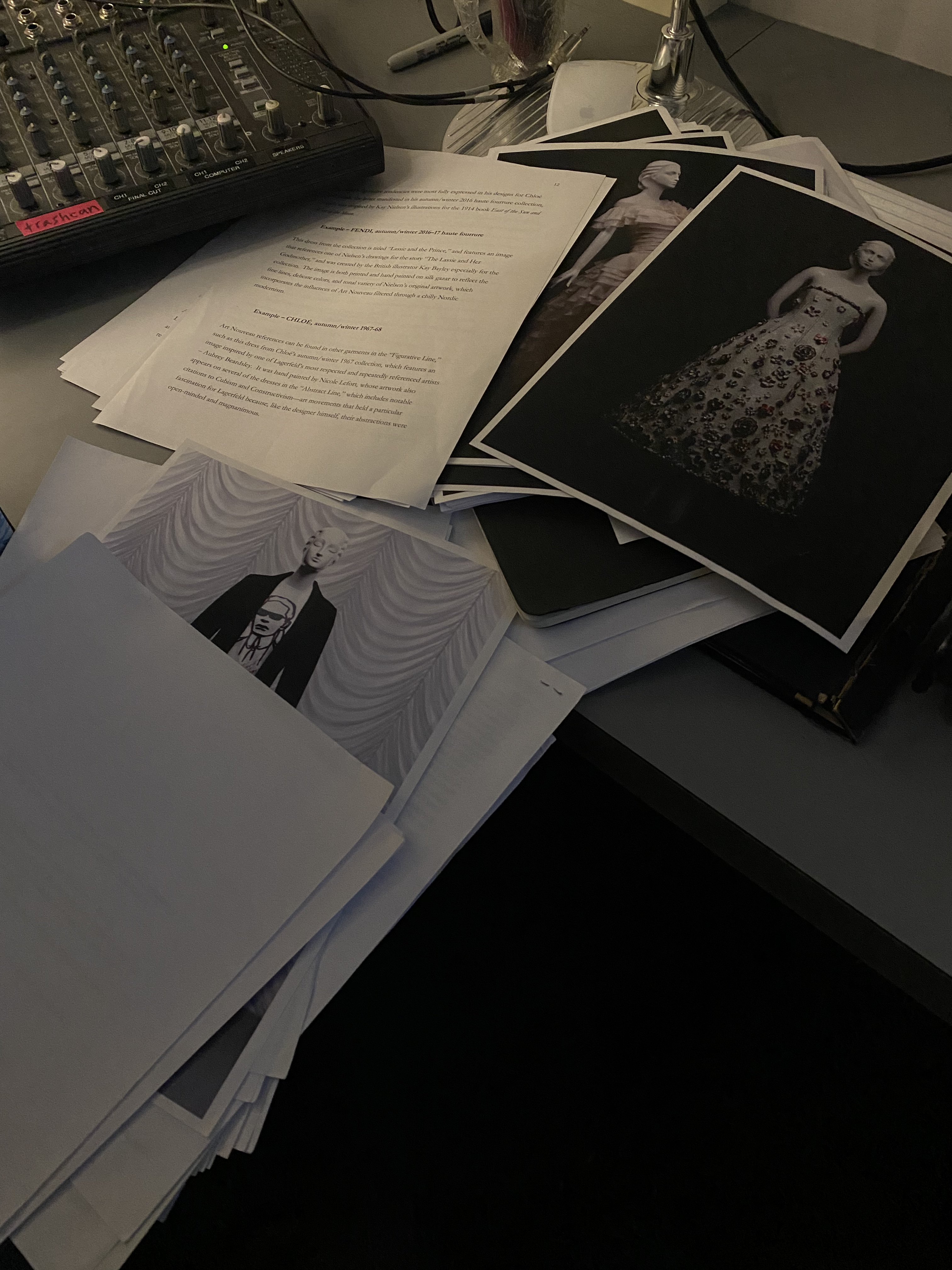 Video Behind the Scenes: a stack of prints and scripts scatter across a dimly lit table.