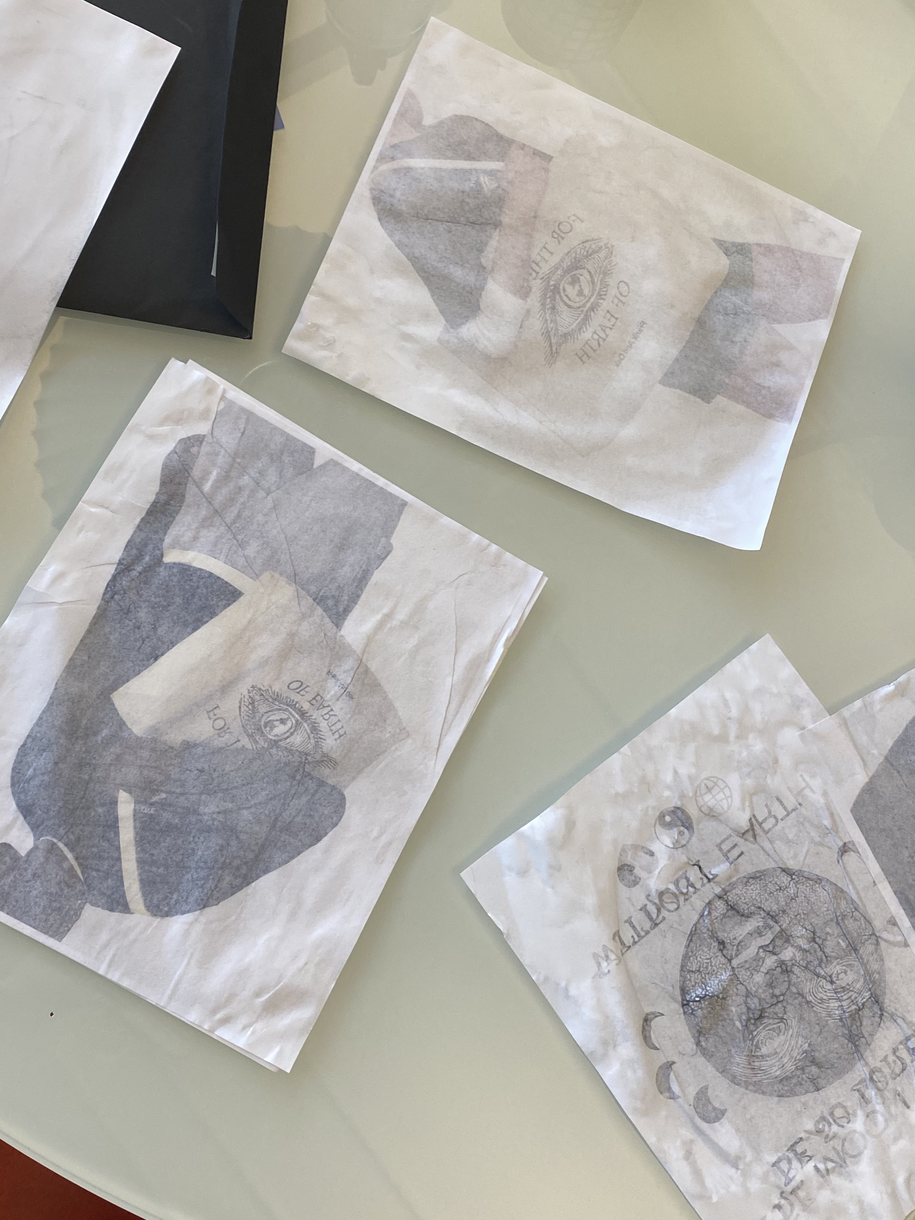 Animation Behind the Scenes: three photographs, aged with water and ink, are spread out on a white table. The photographs contain models carrying white tote bags.
