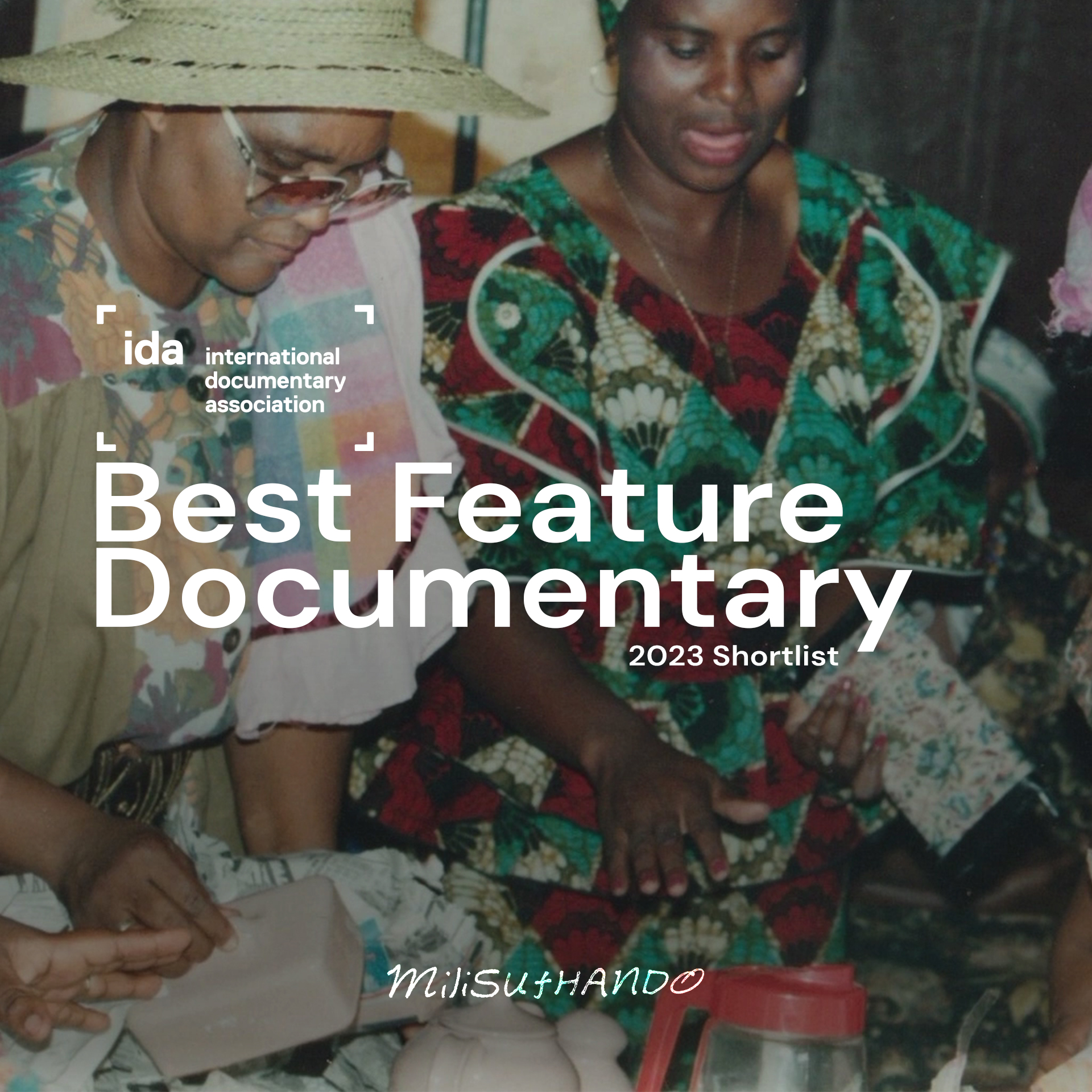 A film laurel of the International Documentary Association and the text 'Best Feature Documentary: 2023 Shortlist,' appears in white against the photograph of two people wearing patterned clothing.