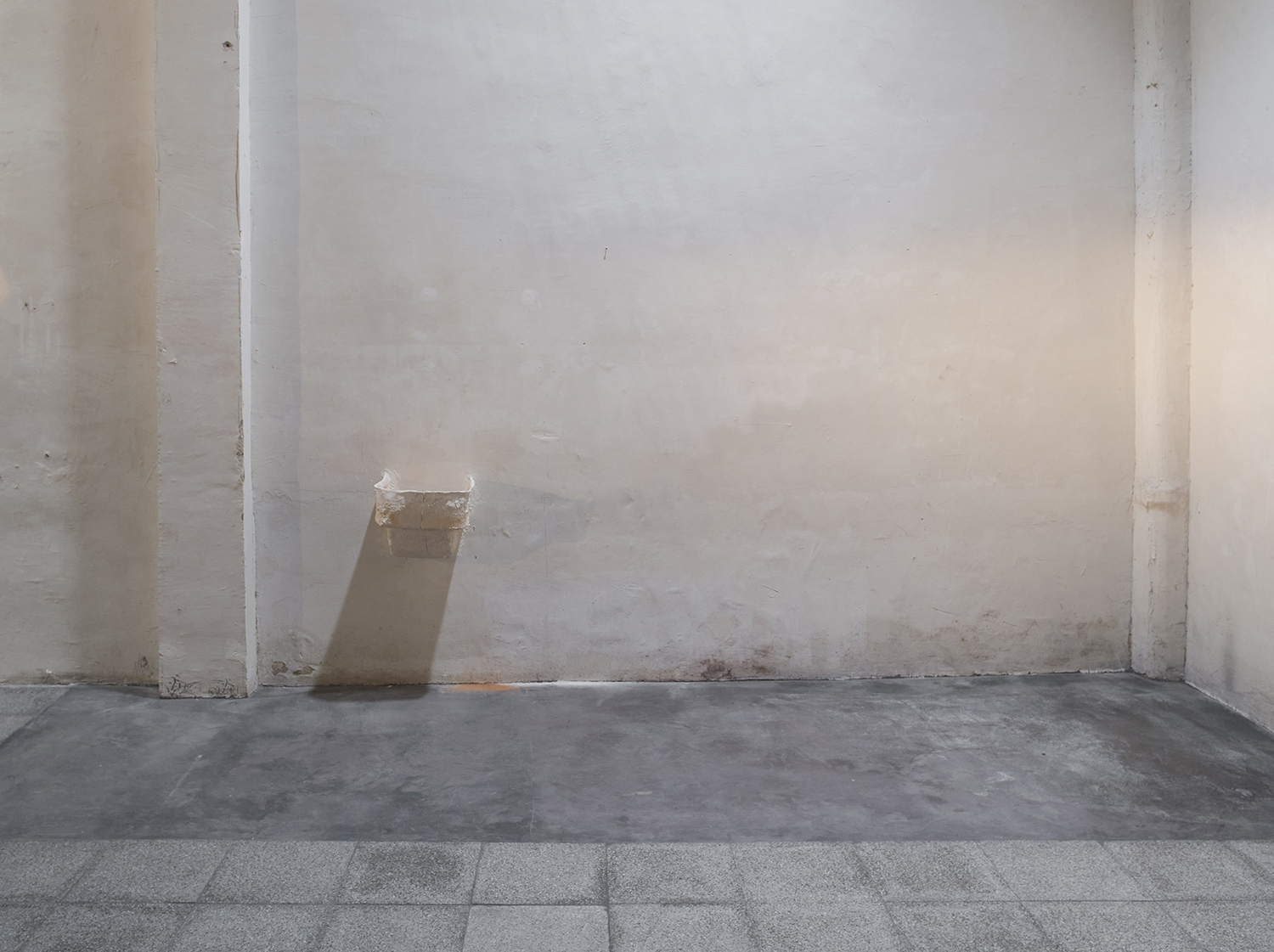 From hip to fingertip (Opel upside down), 2022. Remainder of the acrylic resin mould of the Opel Olympia sculpture made in collaboration between the artist and his father, putty on wall, iron rods and remains of the wall on the floor. 33,5 x 35,5 x 30 cm.