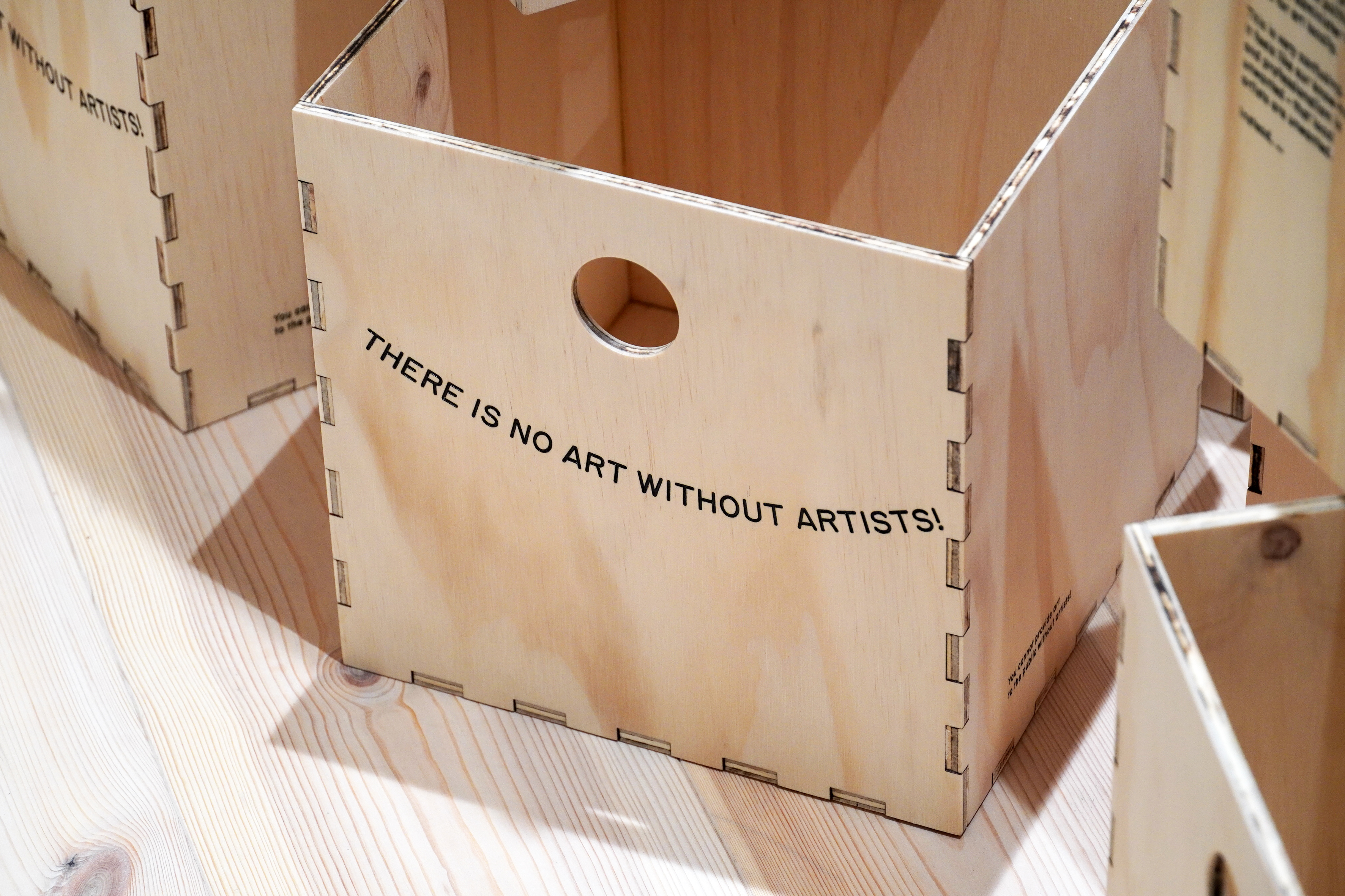 Wooden storage boxes with statements calling for policy changes within the local visual art scene in Aalborg,  The Department of CCCC (Culture, Care, Commoning, and Critique), Aalborg Artist’s Association (AAAA), lím collective, Aalborg, 2022