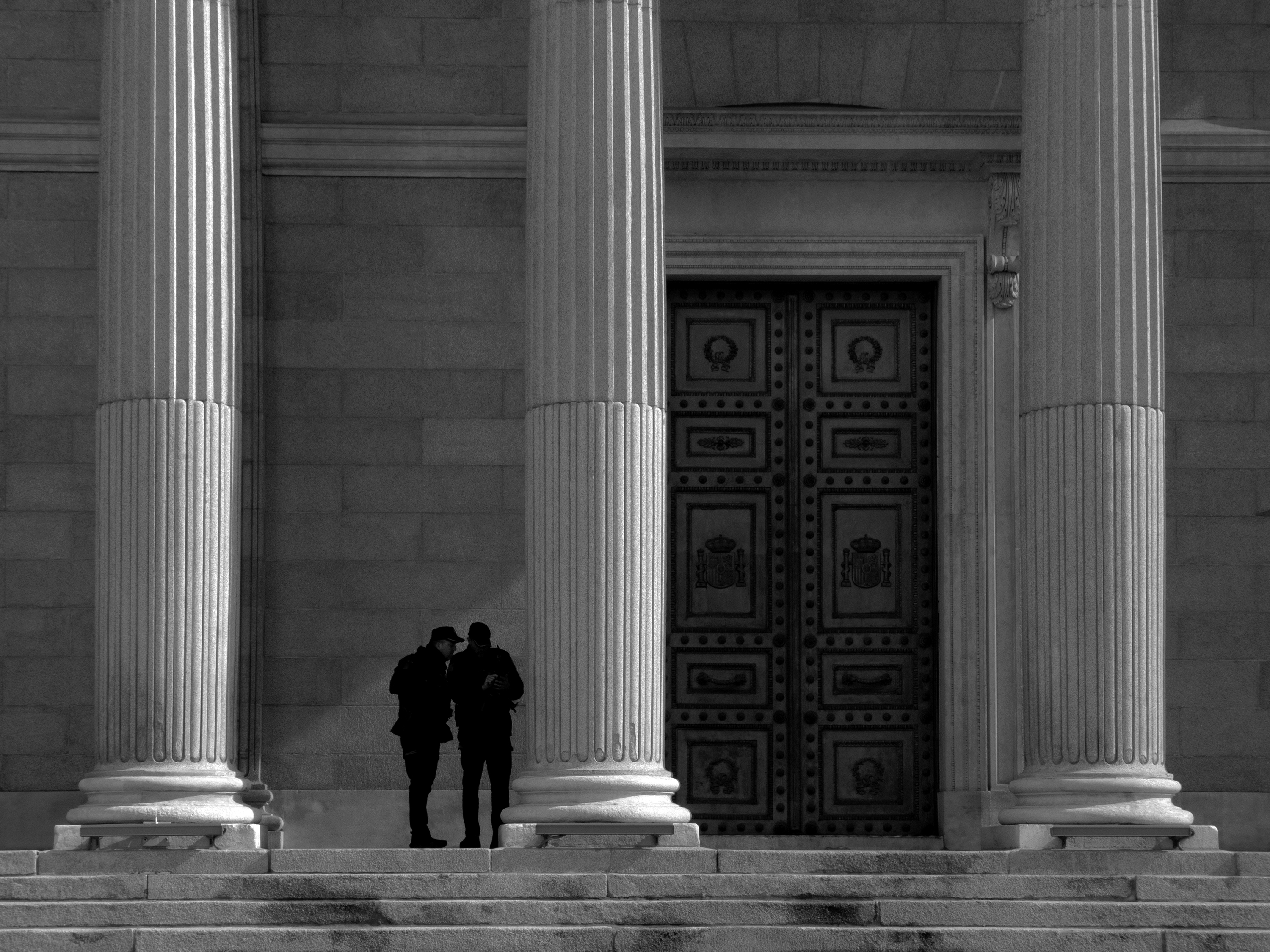 One door, two policemen, three columns and four stepsMadrid, Spain, 2025photography, bw, single