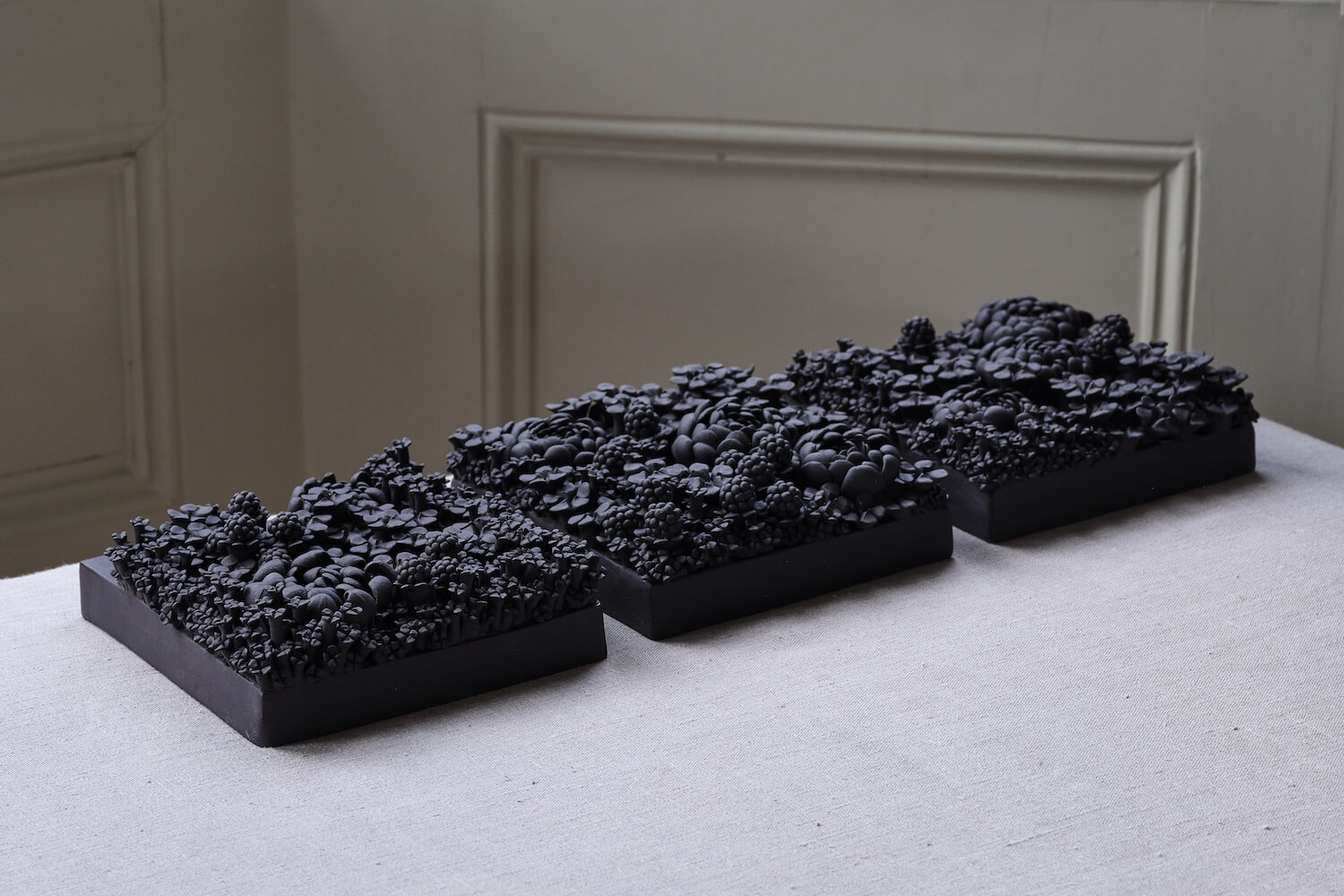 Three black porcelain tiles with 3D flowers