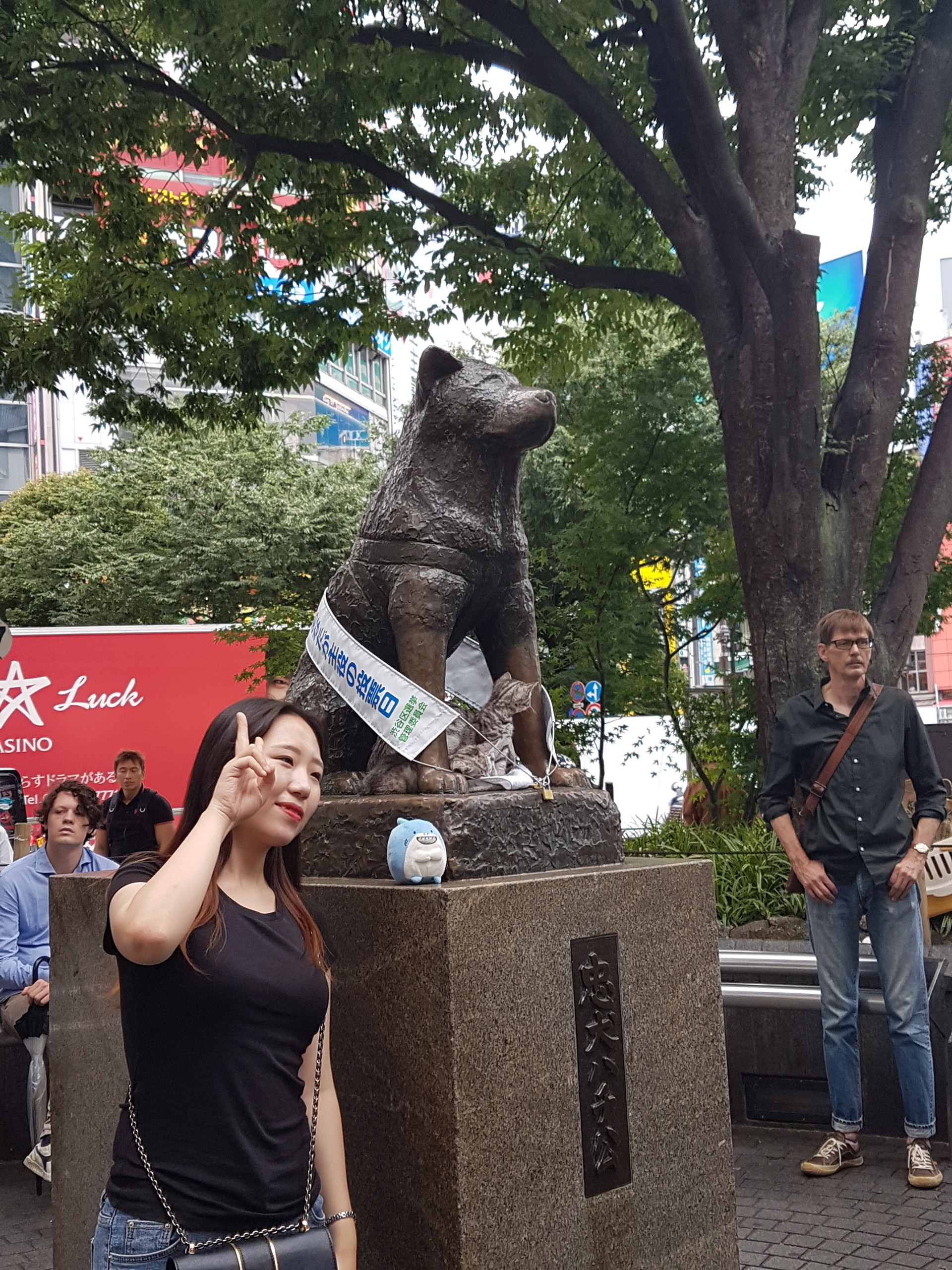 age of tourist posing with Hachiko statue outside of Shibuya Station, Japan