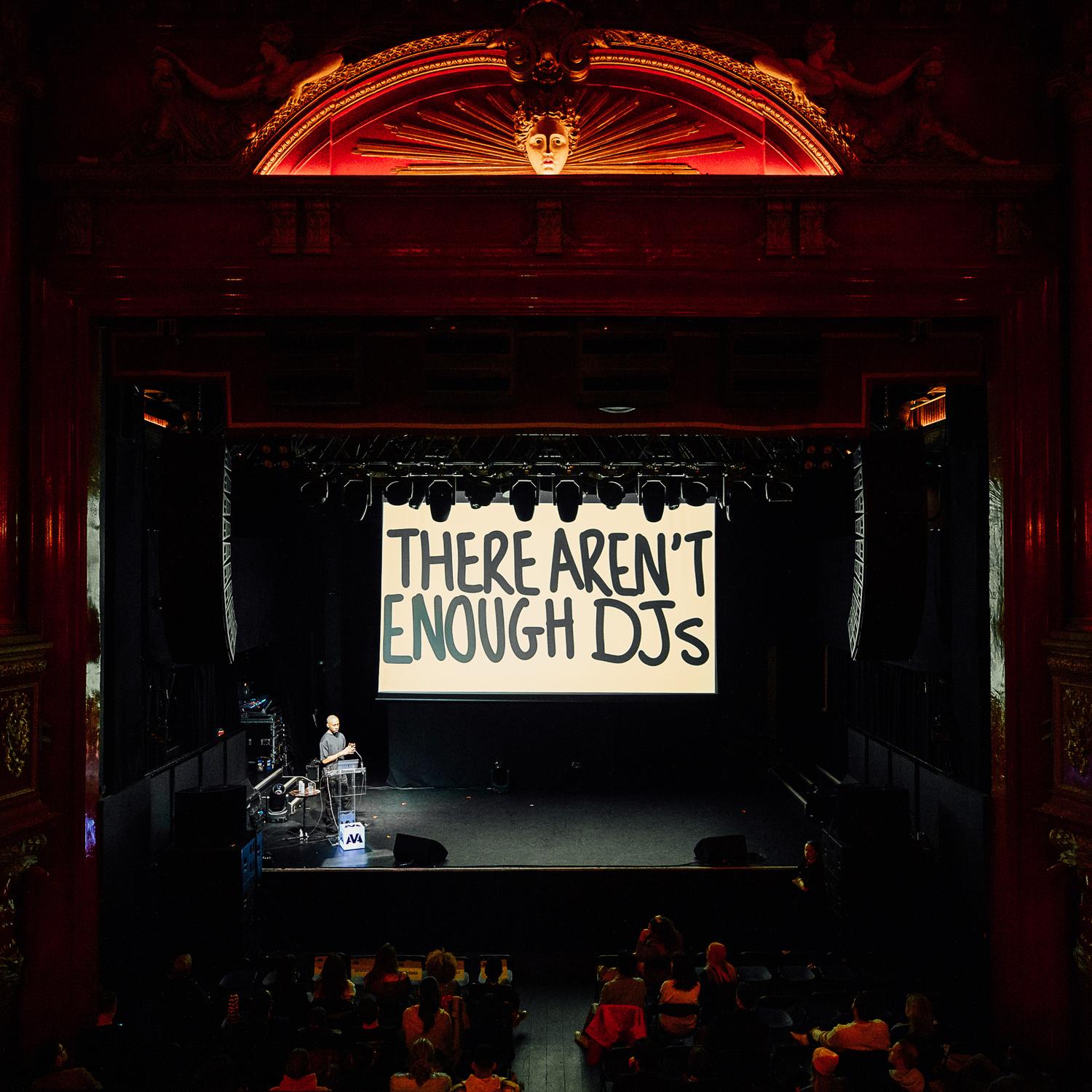 Keynote stage at AVA London with large screen reading 'There Aren’t Enough DJs' in bold text.