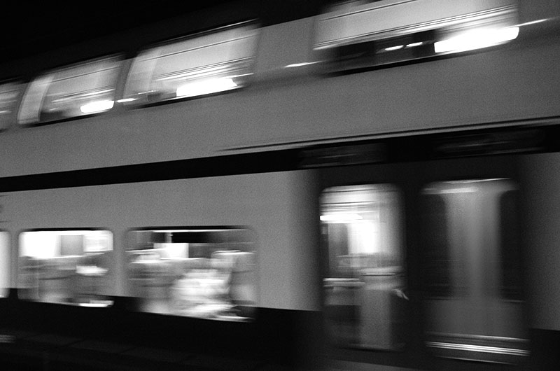 In vorbeizeihenden Waggons verschwommene Gesichter kaum zu erkennen.