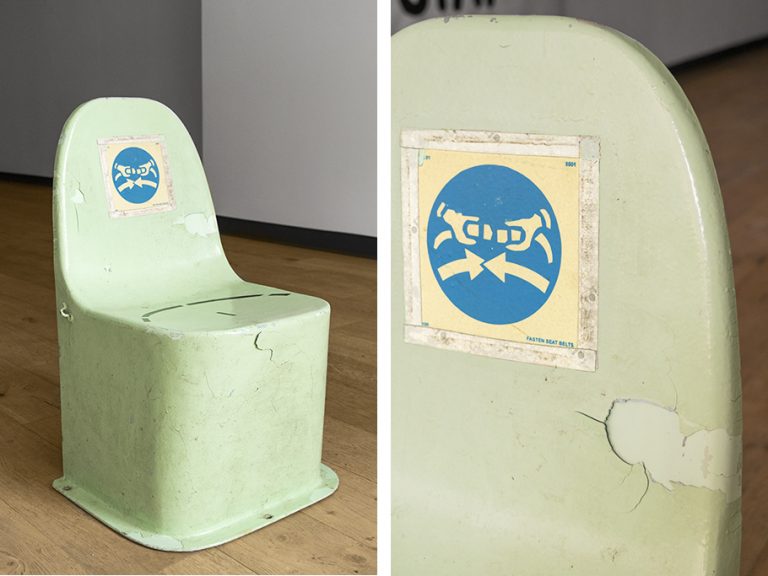 A photo of an industrial green fibreglass lifeboat seat. On the right is a close up of the same seat. The seat has cracks in it and has a blue circle on the back of the seat with a seatbelt symbol inside.