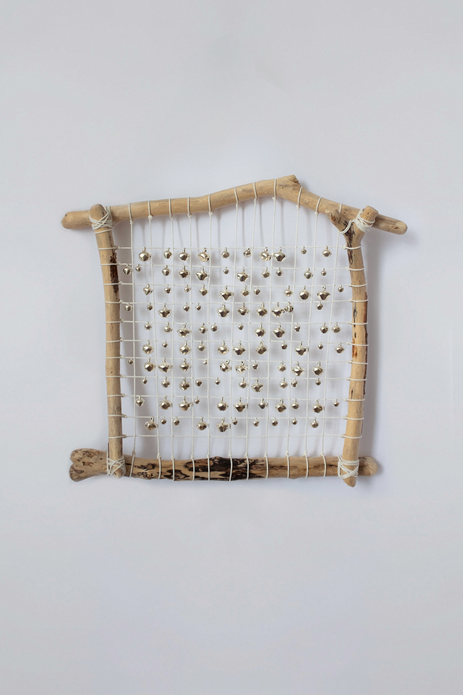 Shield "Boundaries", 2025, seaside sticks, bells, thread, 33х30 cm