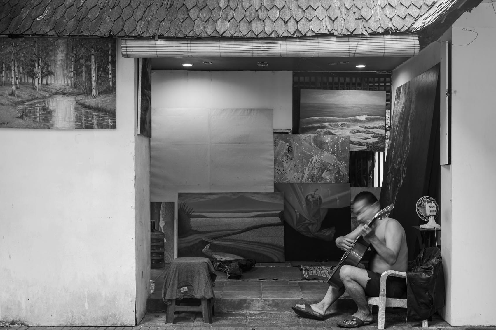 2. Dari kesunyian yang ada, terdengar alunan suara gitar dari seorang seniman yang bernama Yudho Kusumo. Sembari duduk santai dan menikmati suasana senja didepan karya lukisan nya yang bertemakan pemandangan.