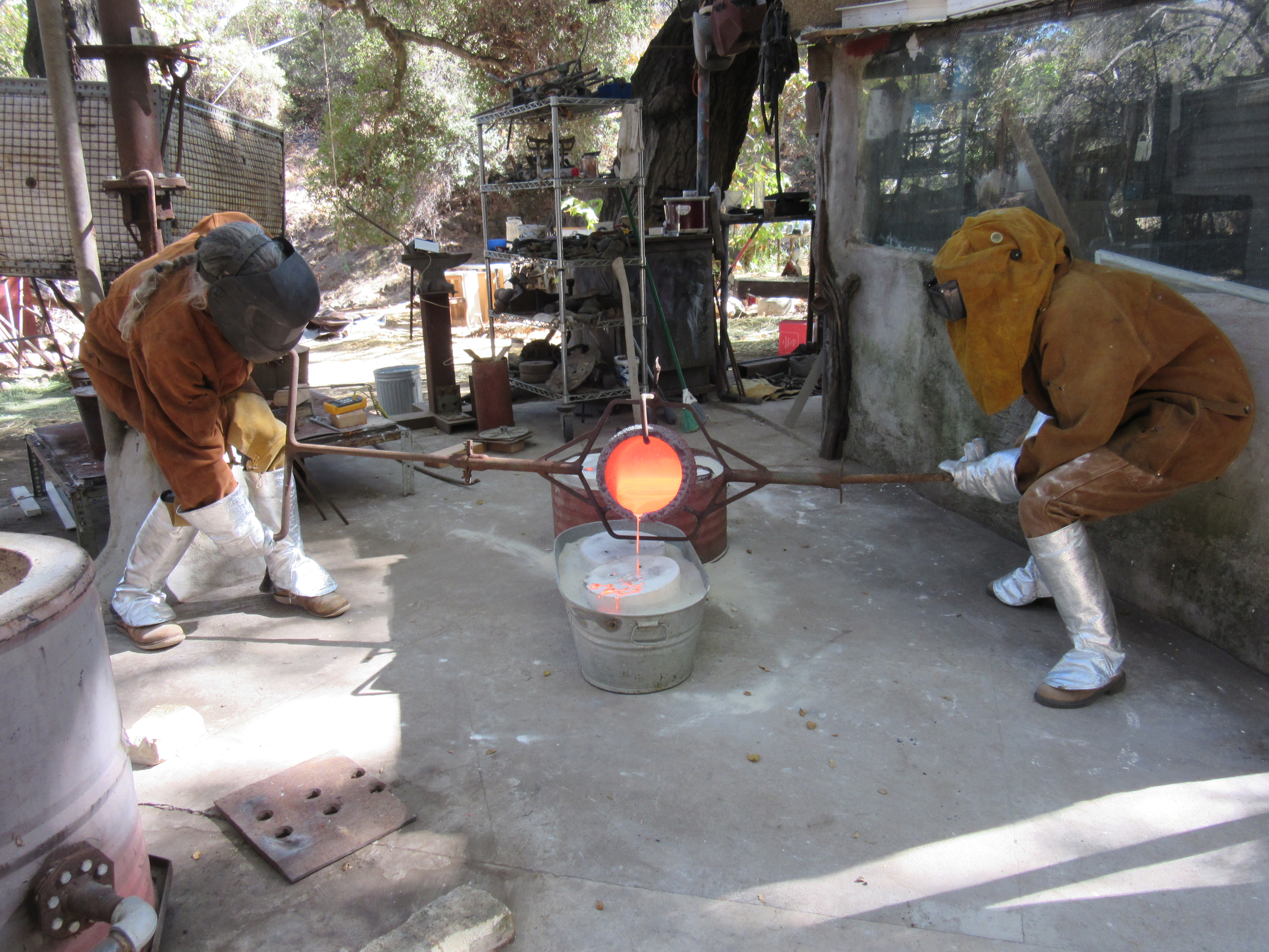 Pouring molten bronze into plaster mold.