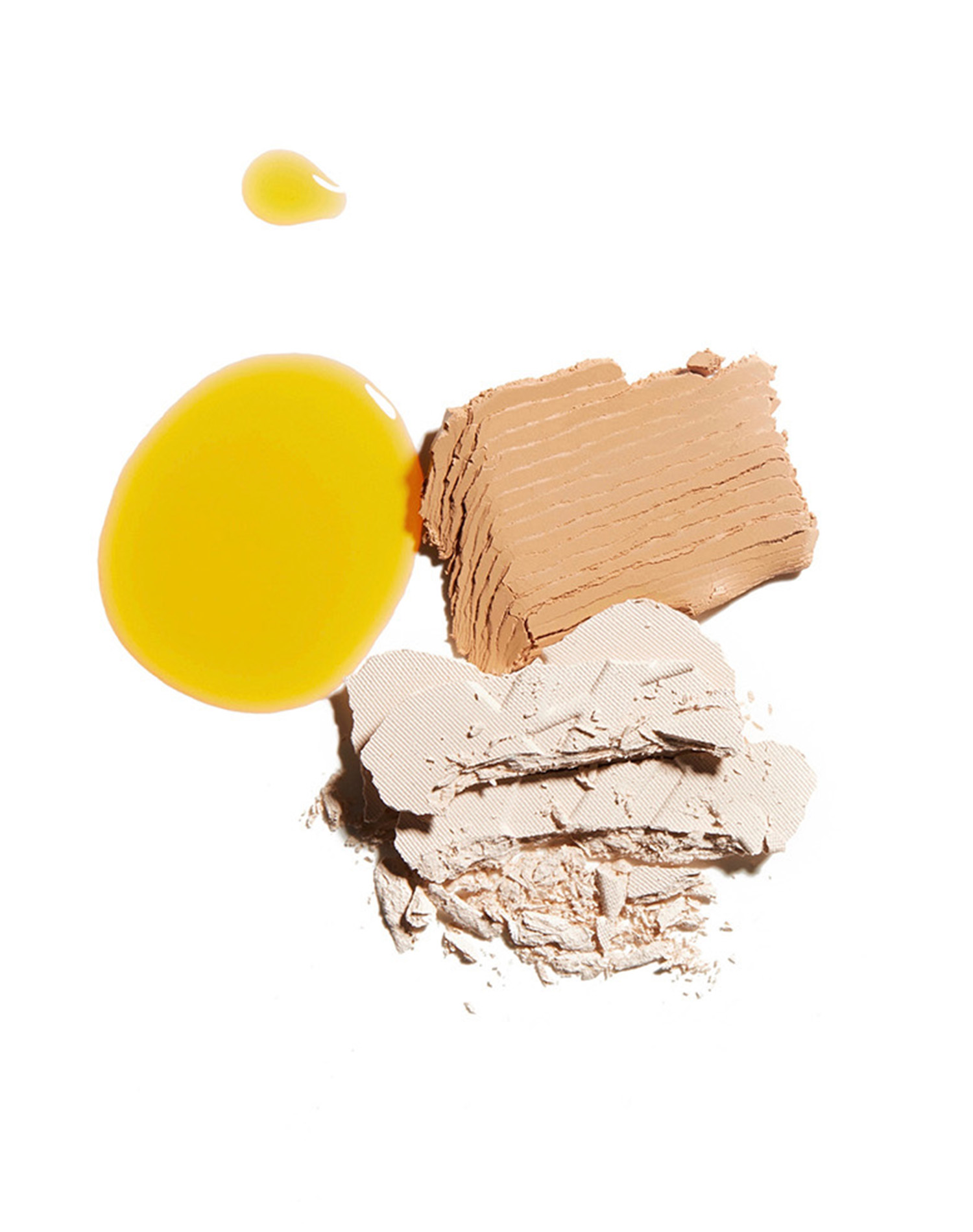 KMA stylist Sara Wacksman designs set for photo of yellow serum and tan powder scattered on a white background for Kjaer Weis