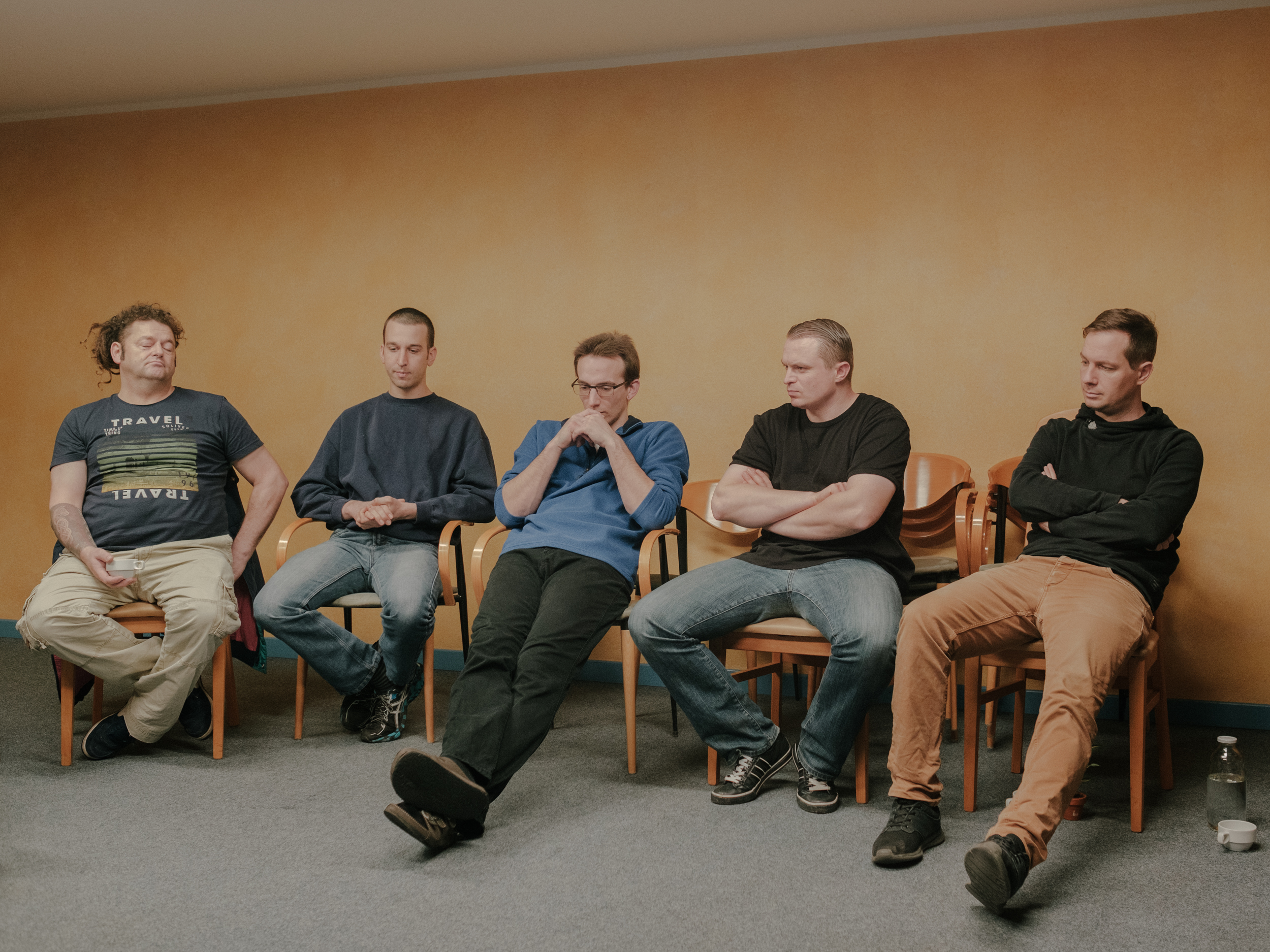 Hofbewohner während einer Gesprächsrunde - Jeden Freitag treffen sich alle Hofbewohner*innen zum sogenannten „Spiel“. Dies dient dazu, seinen eigenen Emotionen freien Lauf zu lassen, um Probleme zu klären, die im Zusammenleben oder im Prozess mit der eigenen Sucht entstehen. Im Alltag versuchen die Bewohner*innen ihre Auseinandersetzungen für sich zu behalten, Dezember 2018. // Farm residents during a group theraphie round - Every Friday, all the farm residents meet for a so-called "game". This is an opportunity to give free expression to one's own emotions in order to clarify problems that arise in living together or in the process of dealing with one's own addiction. In everyday life, the residents try to keep their struggles to themselves, December 2018.