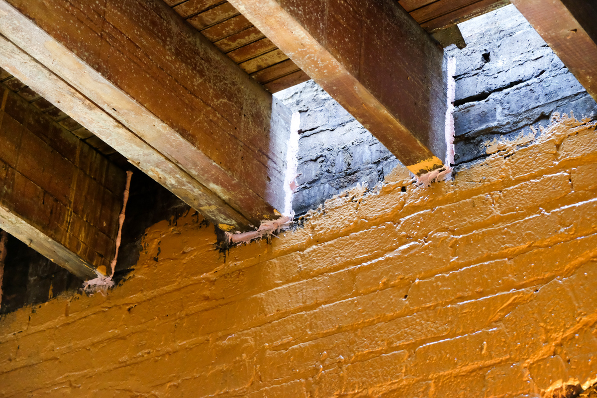 Air sealing inside of masonry walls at floor joist pockets during construction