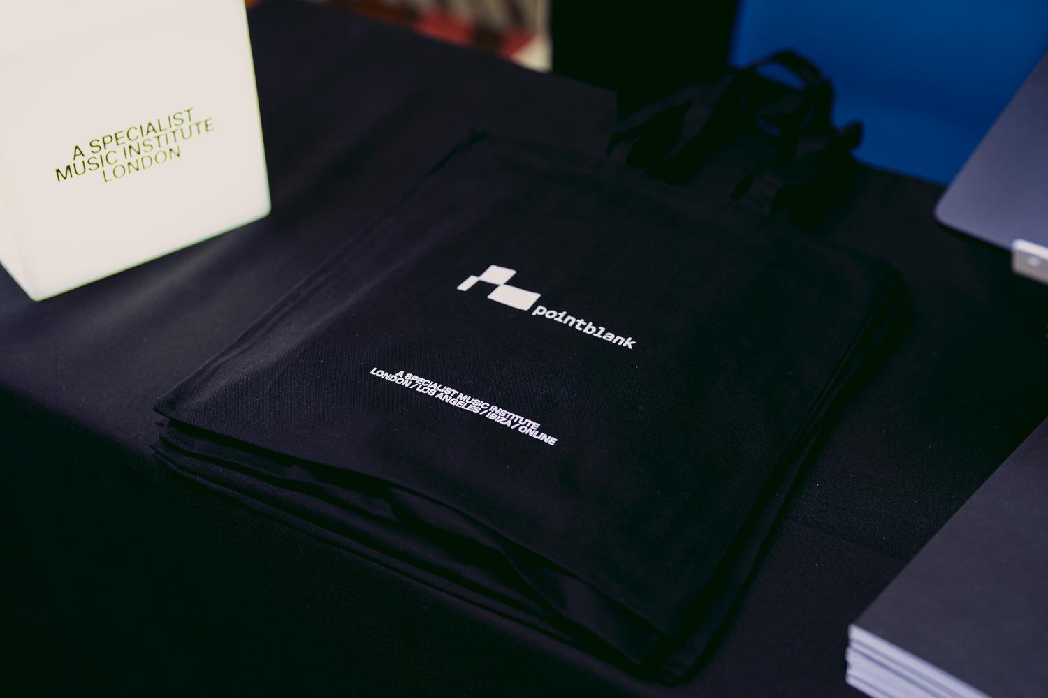 Point Blank Music School tote bags and materials displayed on a stand at AVA London 2025.
