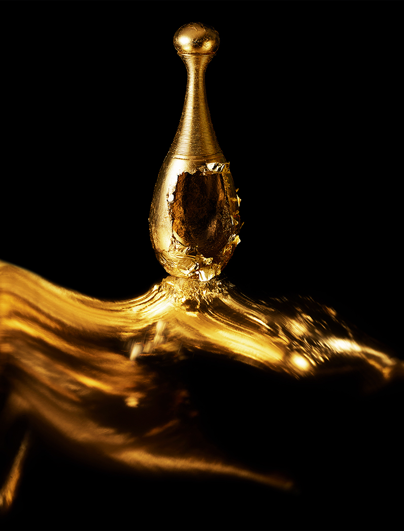 KMA photographer Isabelle Bonjean shoots a close up photograph of a bright gold perfume bottle for Faux Q Magazine 