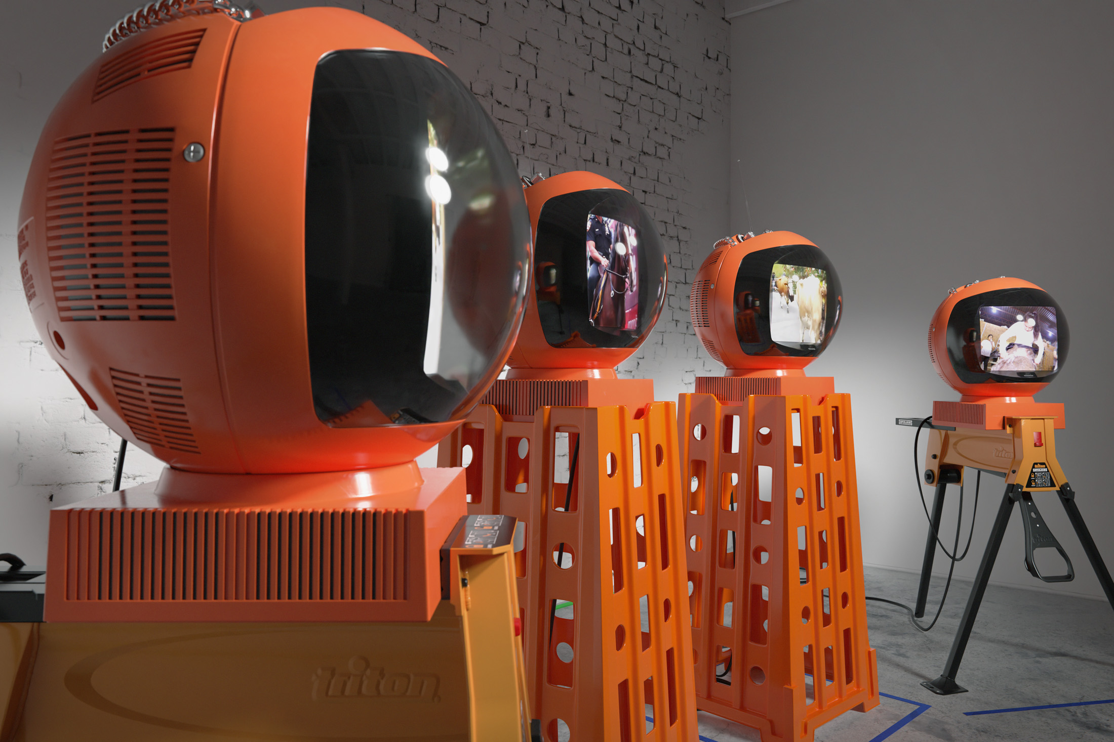 Echoes in an empty cage, 2023, refurbished videospheres, superjaw sawhorses, standtalls, media players, cables, tape, dimensions variable