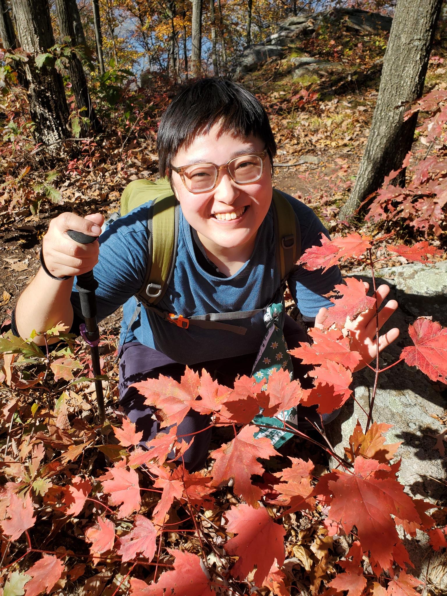Smiling among the leaves and in the trees at Breakneck Ridge.  Photo by Colin English. October 27, 2022.
