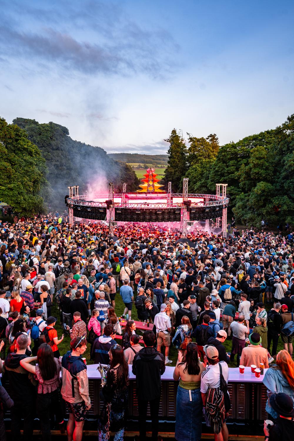 Aerial view of AVA x Smirnoff IMMERSE stage surrounded by festival crowd and scenic landscape