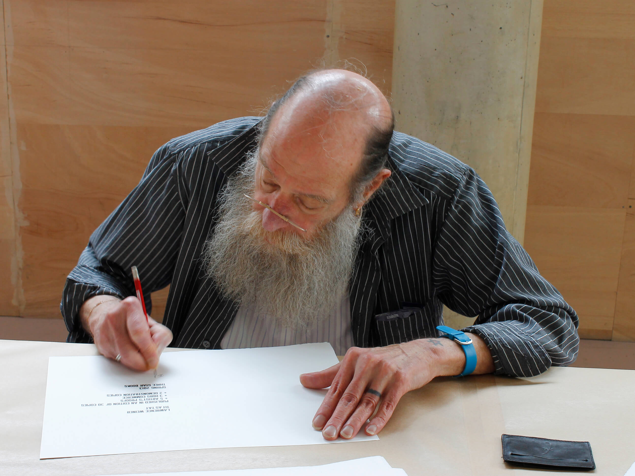 Lawrence Weiner signing “TIT AS TAT”