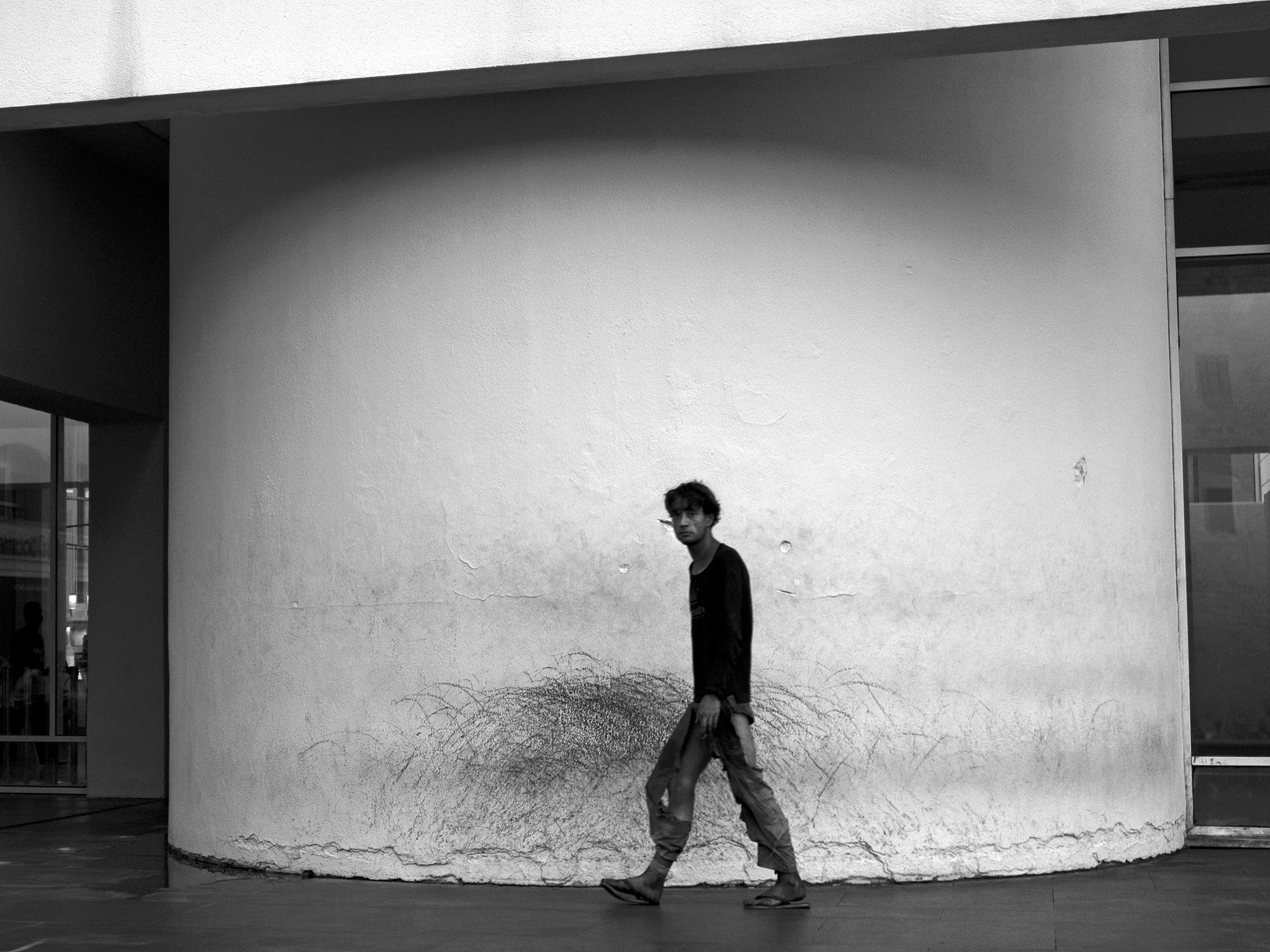 Homeless passing by a museum of contemporary art Barcelona, Spain, 2023photography, bw, single