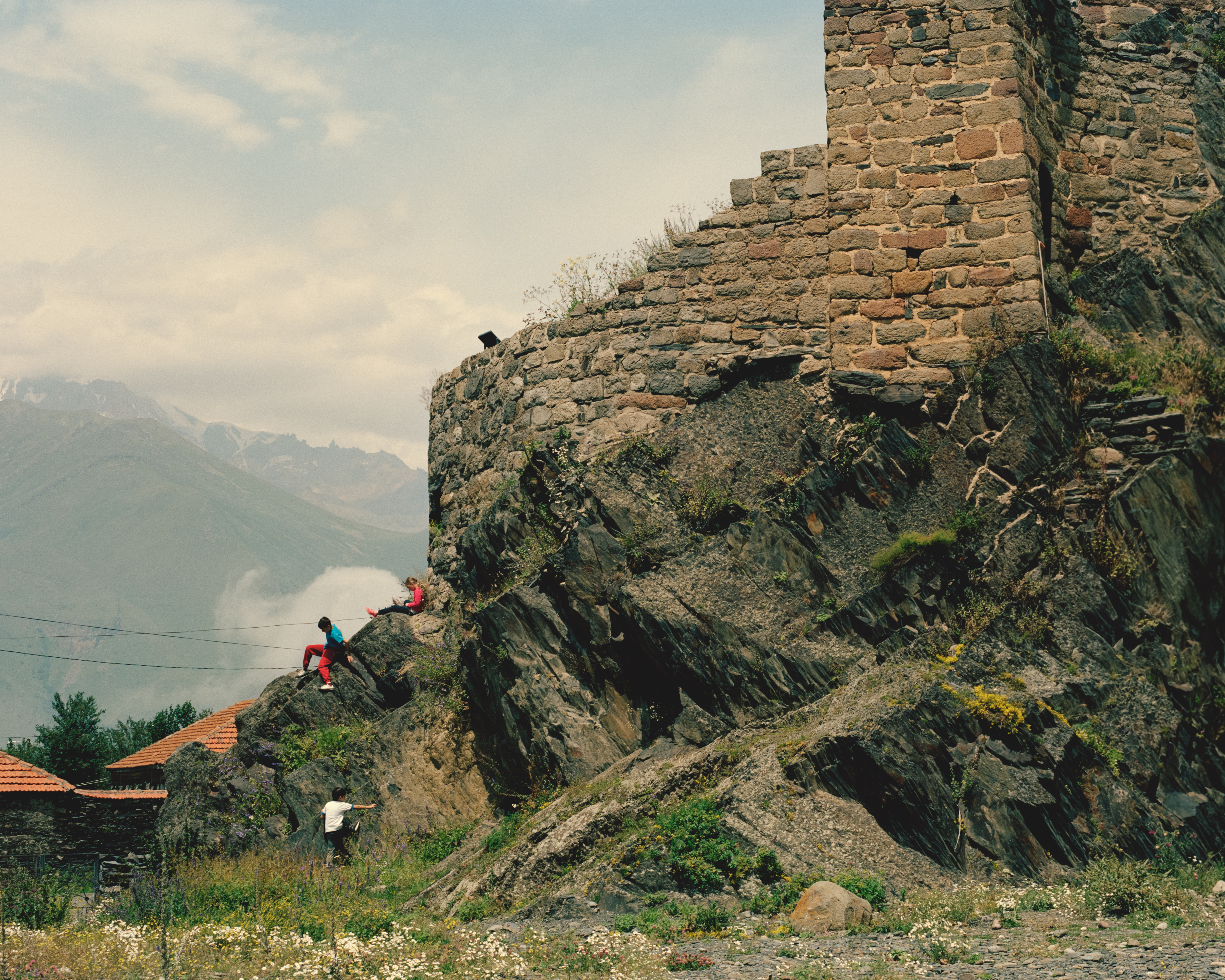 Children climbing on an old church ruin near Stepantsminda, Georgia