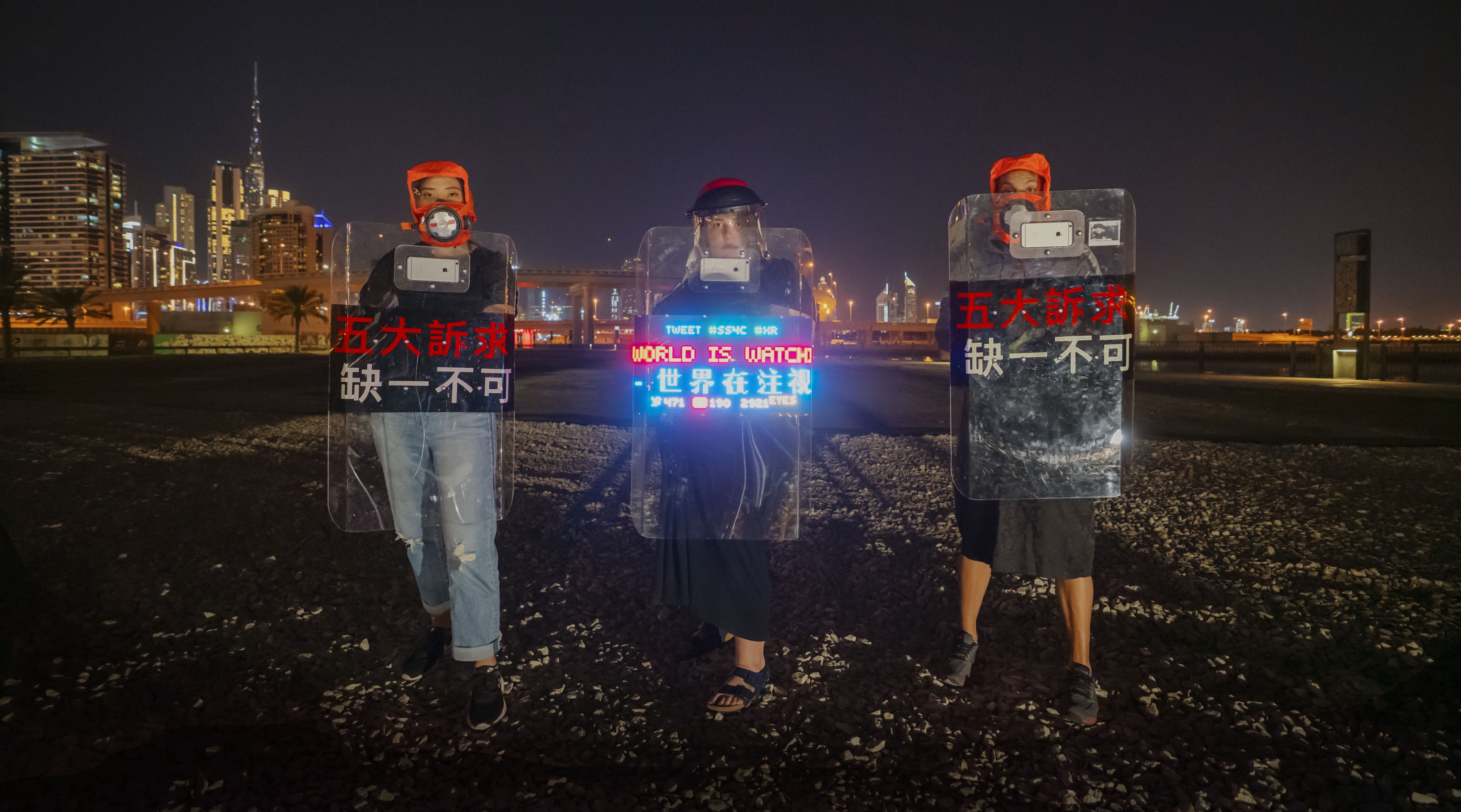 The World is Watching, Nov 2019These "Smartphone enabled riot shields" were assembled inside the Global Graduation show 2019 by three residence of hong kong. The were then taken to the streets of Dubai for a demonstration of solidarity with the Free Hong Kong Movement. The World is Watching is a reference to the brutal Chicago riots of 1968. The photo and shields were later included in a World Press Photo exhibition titled "“Be Water!” - The Strategy of Resistance in the Hong Kong Protests.