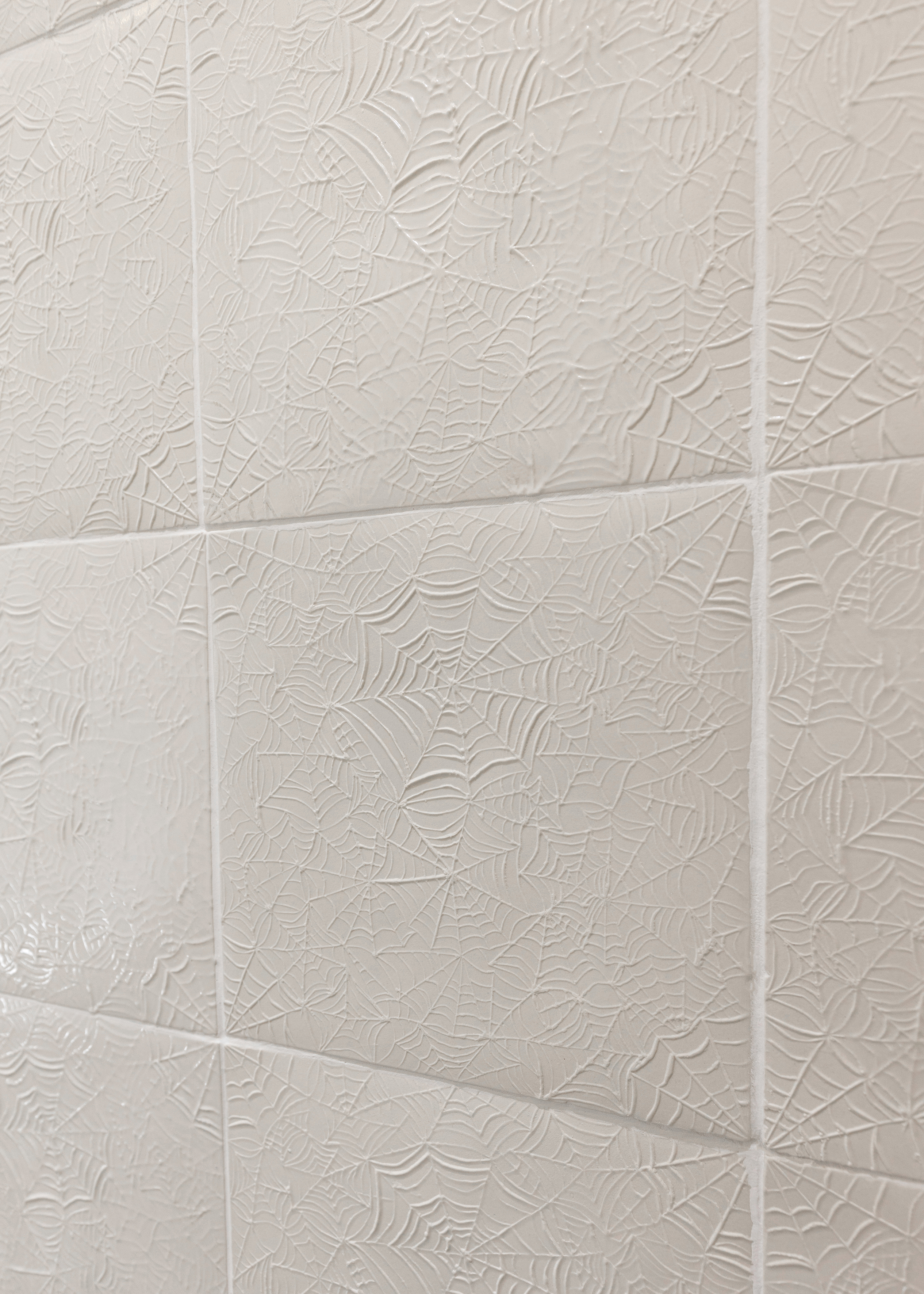 Handmade ceramic tiles with texture and pattern of spider webs. Photography : Anat Finkelstein