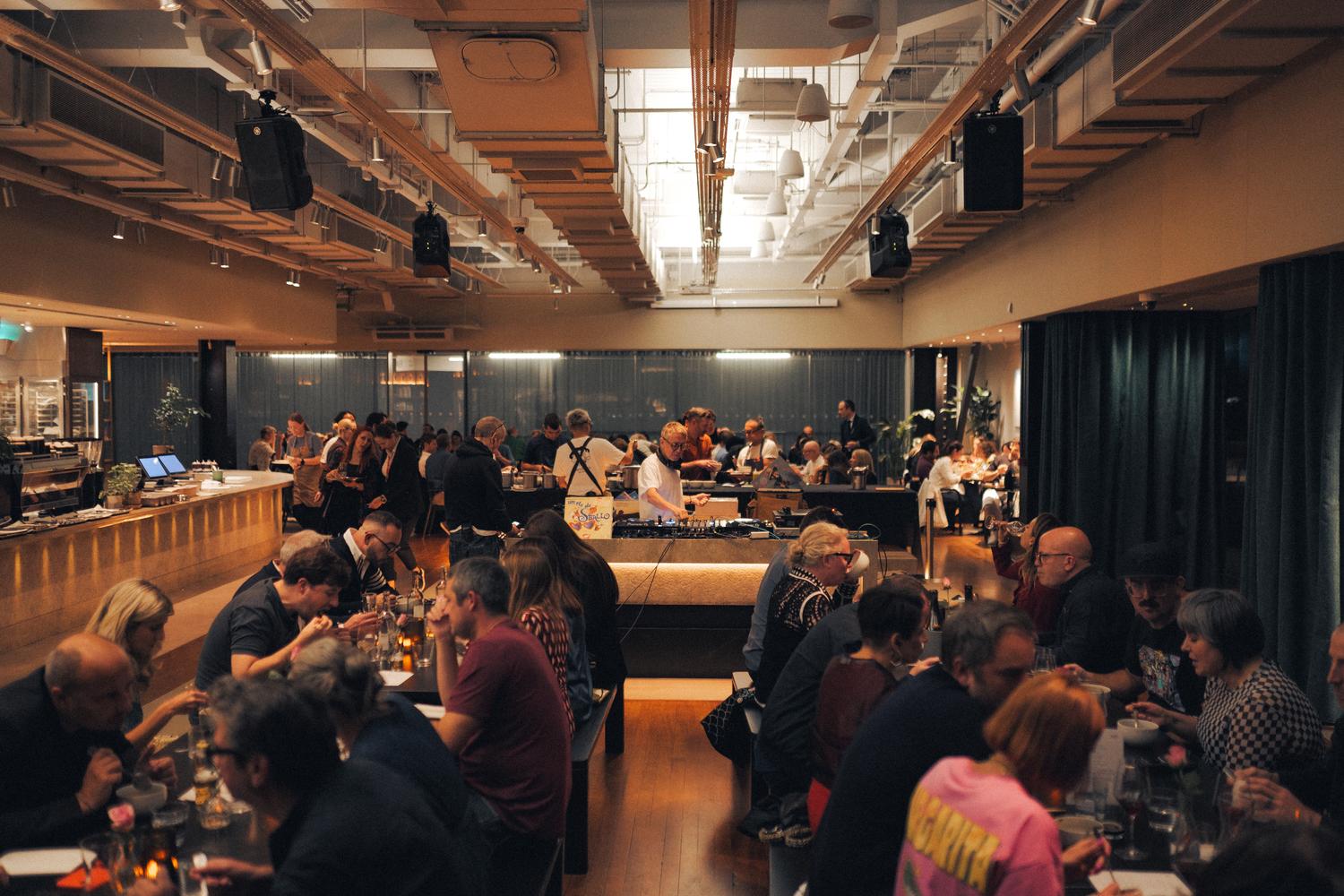 Guests dining at the Paired × Tate Modern event while Gilles Peterson performs behind the counter.