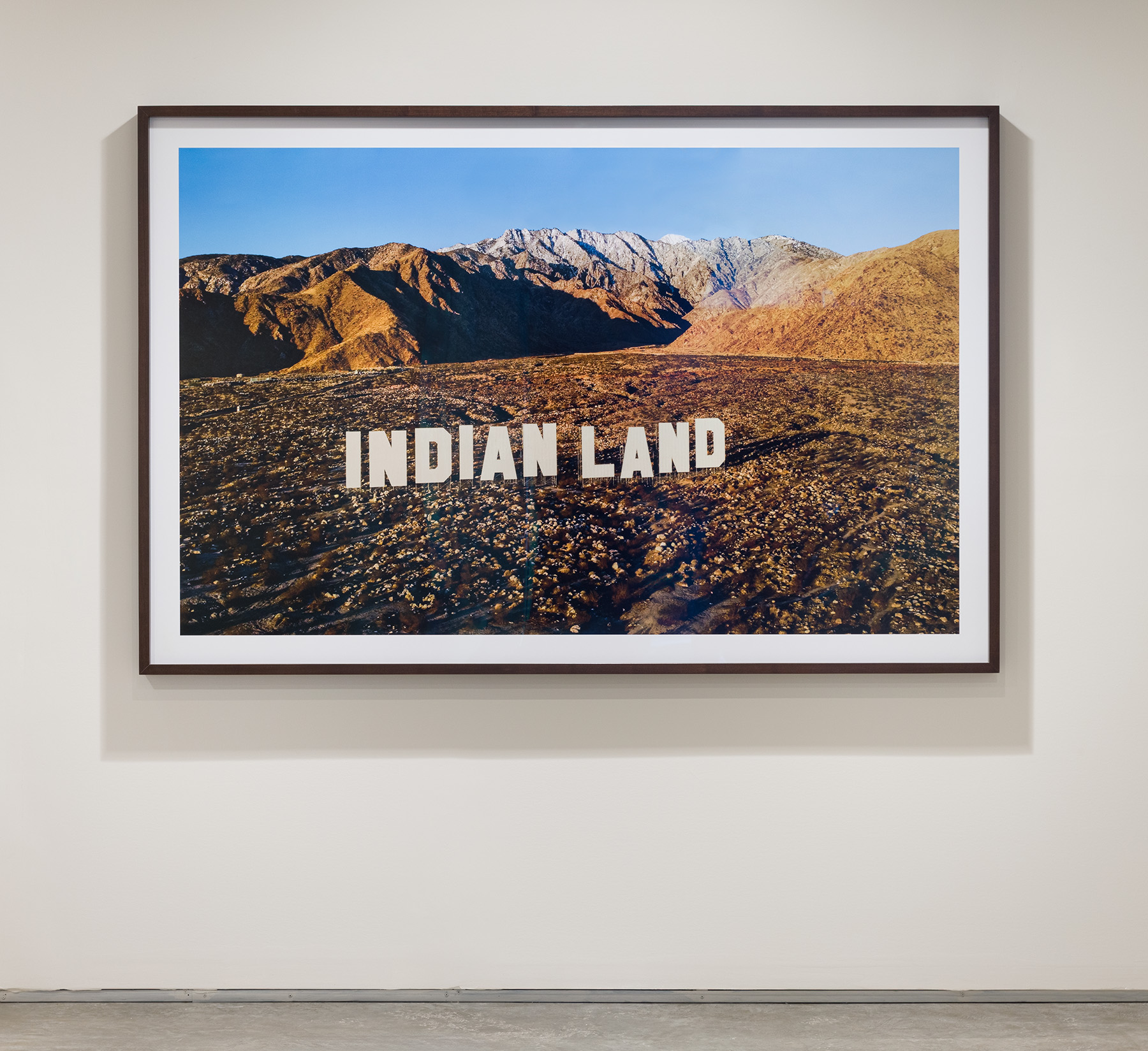 Nicholas Galanin, Never Forget, 2021. C-print mounted on Dibond, walnut frame, 51 3/4 x 78 3/4 inches. Courtesy the artist and Peter Blum Gallery, New York.Photo by Etienne Frossard.