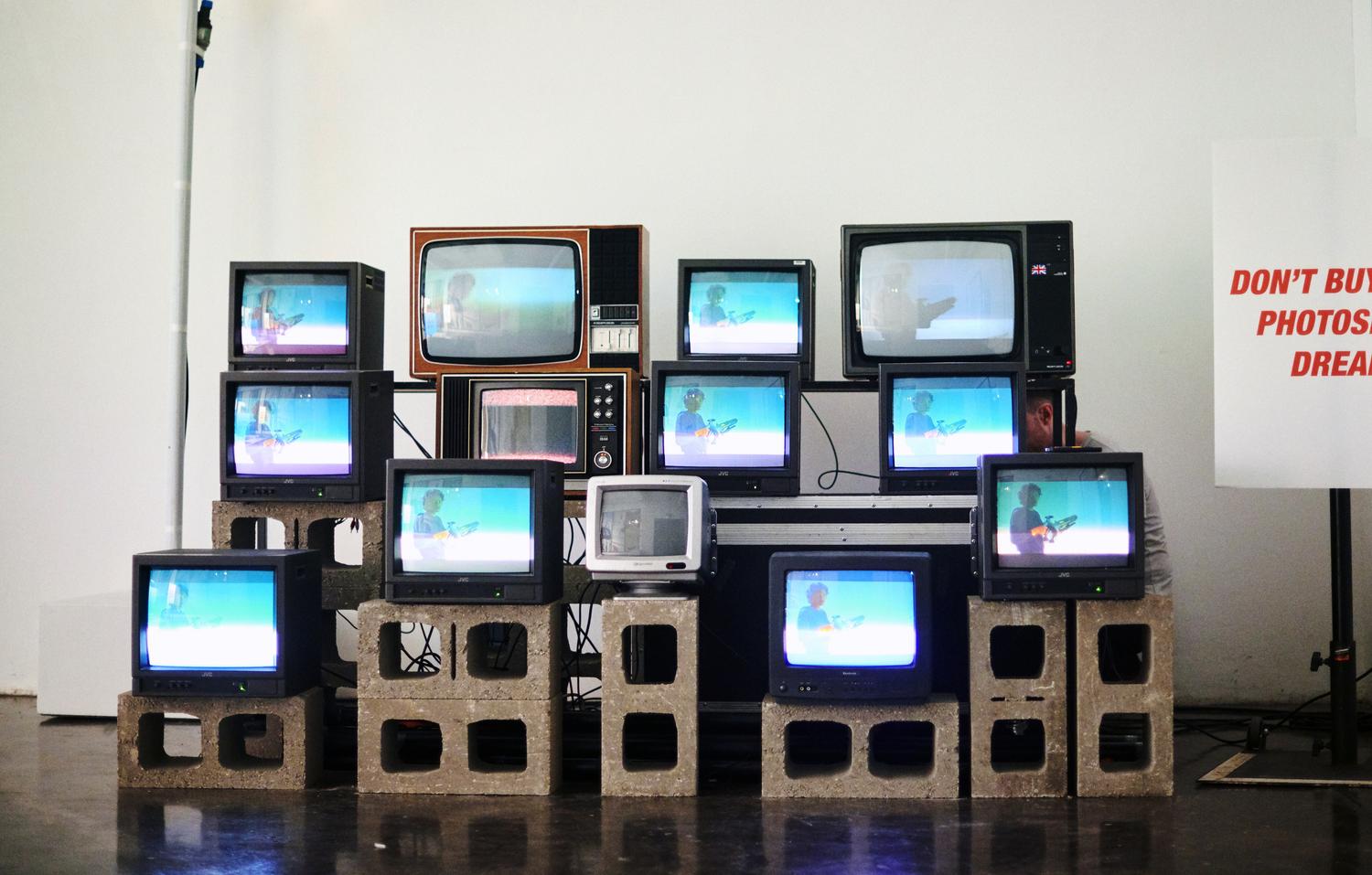 Stack of retro televisions playing looping visuals at EVO Hair “Don’t Buy This” event in London.