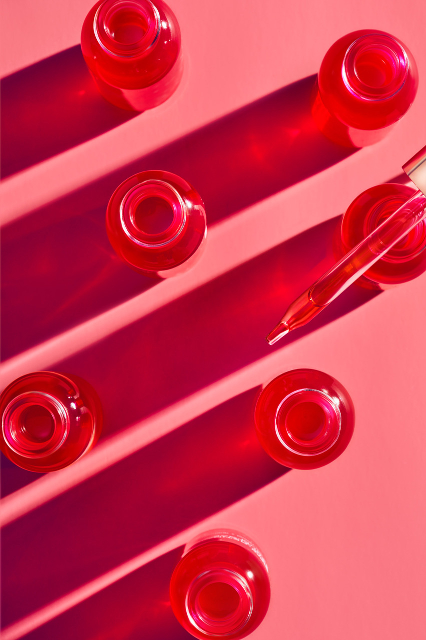 KMA stylist Sara Wacksman designs set for a texture photo of silky red serum drizzled on a pink background for Josie Maran