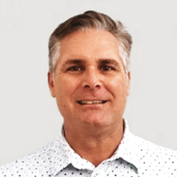 Headshot of Chris Dwyer. He is wearing a polka dot button down shirt.