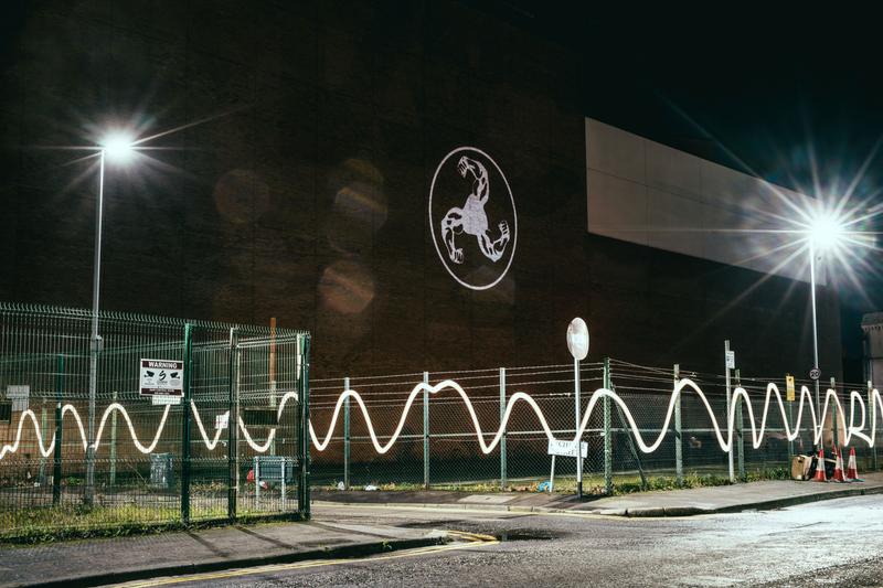 BICEP logo projected onto a Belfast wall at night with curved light trails in the foregroundBICEP logo projected onto a Belfast wall at night with curved light trails in the foreground
