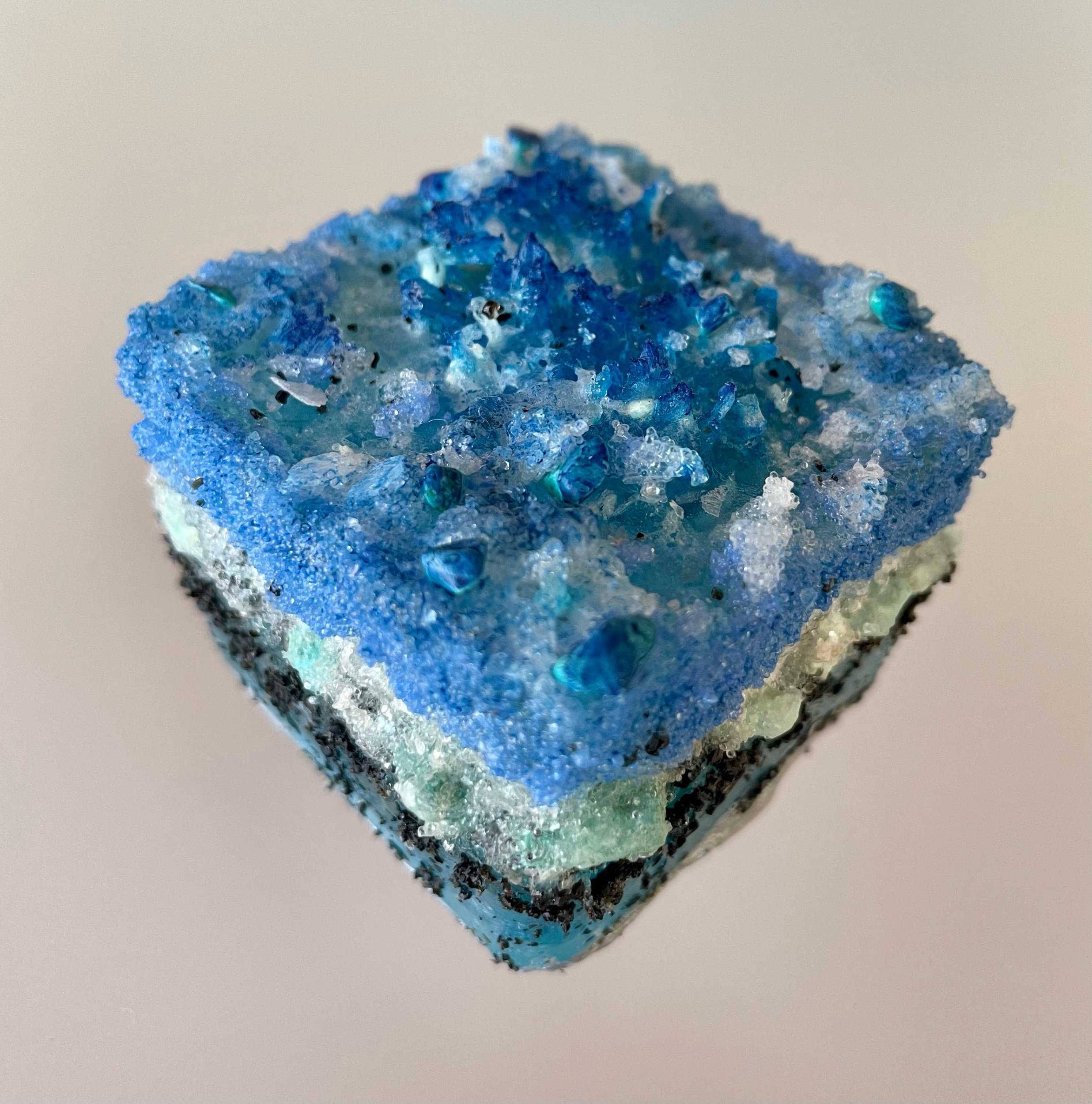 Blue Terraform: Layer Cake; Crystal quartz, magnesium, turquoise, mica flakes, glass, blue quartz aggregate, clay with aluminum finish, phosphorescent mineral powder, resin, 2”x2”x2.5”