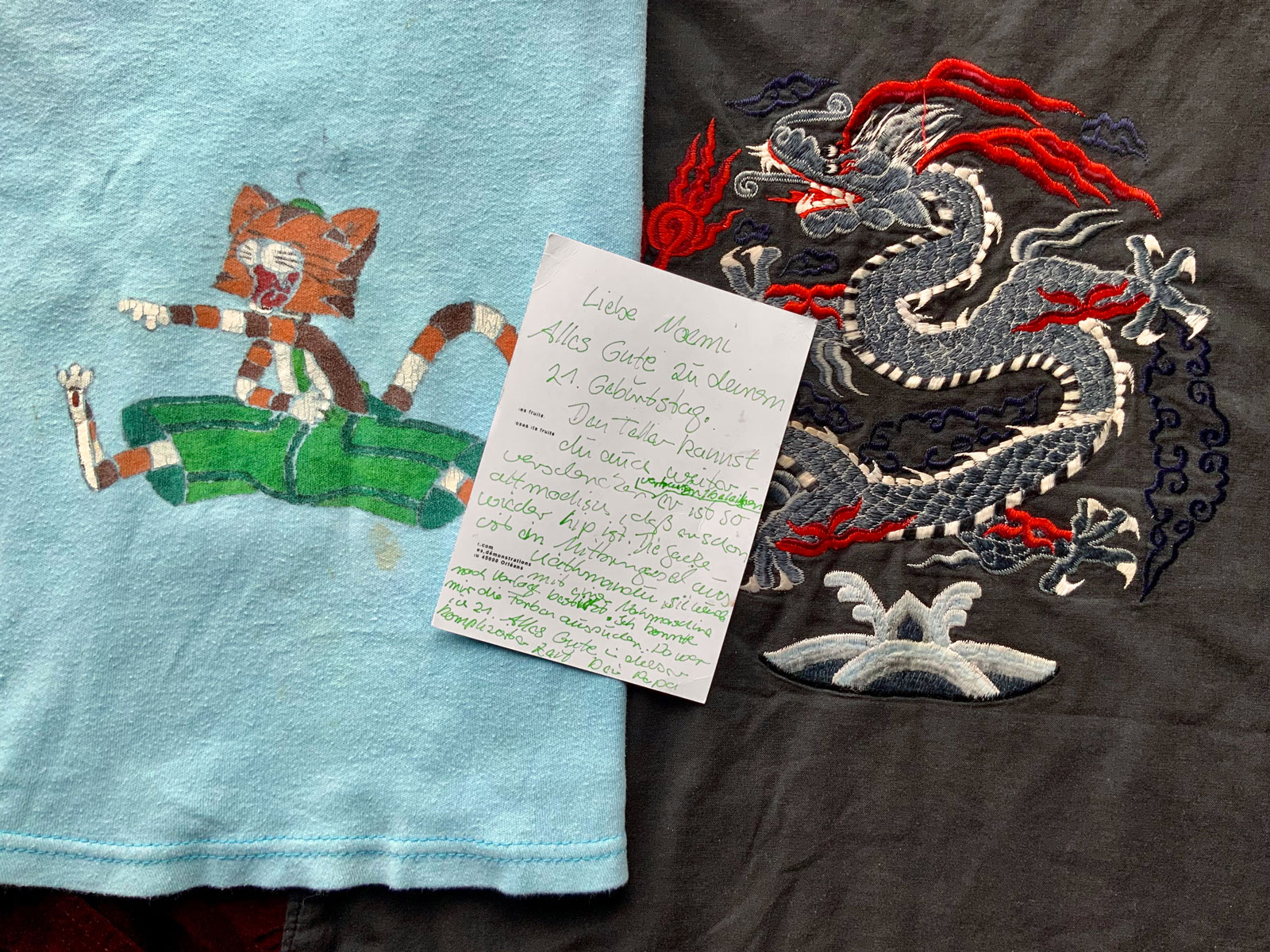 Noemi's clothing from her parents, together with a postcard from her father about the story of the handmade vest to the right. Courtesy of Noemi Braun.