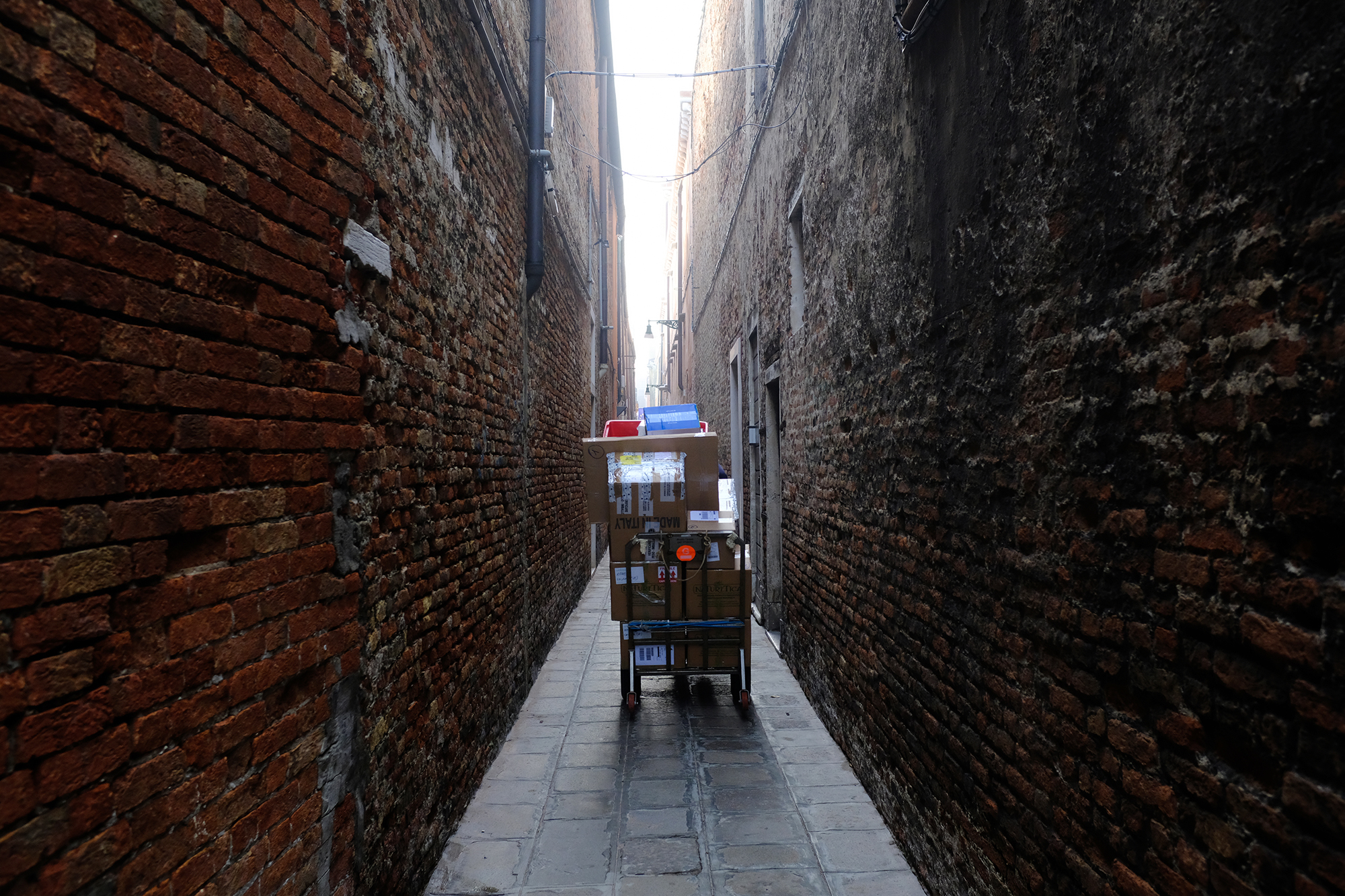 Philippe-Sarfati-reportage-photography-photographer-street-documentary-photojournalism-photojournalist-covid-19-pandemic-venice-italy-narrow-street-amazon-cardboard-boxes-delivery