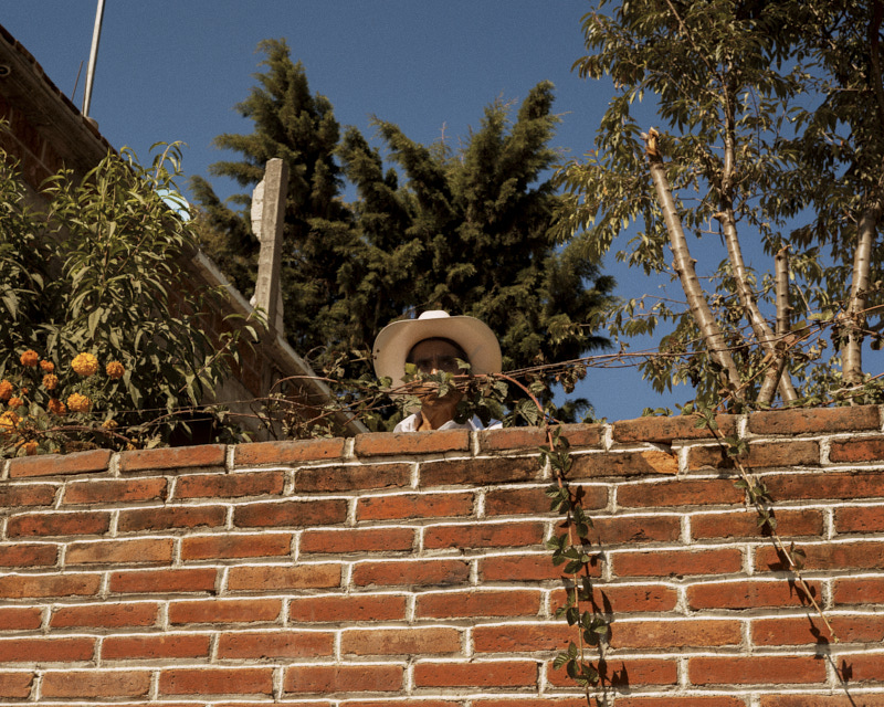 A man assisting a political speech from behind his house’s yard. San Antonio Alpanocan, Puebla, Mx, Nov 17.