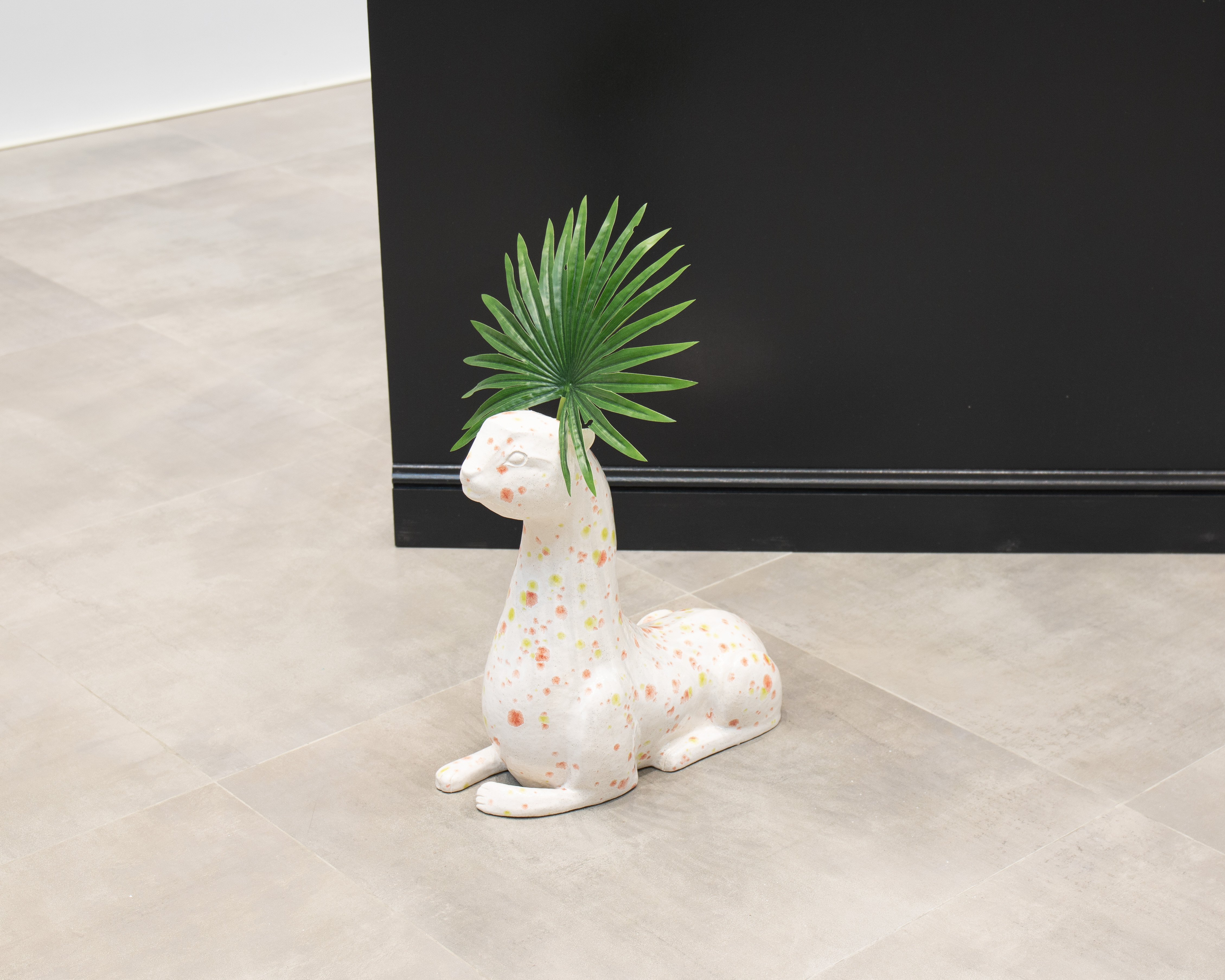cat ivearthenware, glaze, plastic palm leaf.cat dimensions  25.7 x 40.6 x 25.4 cm (18 x 16 x 10 in)