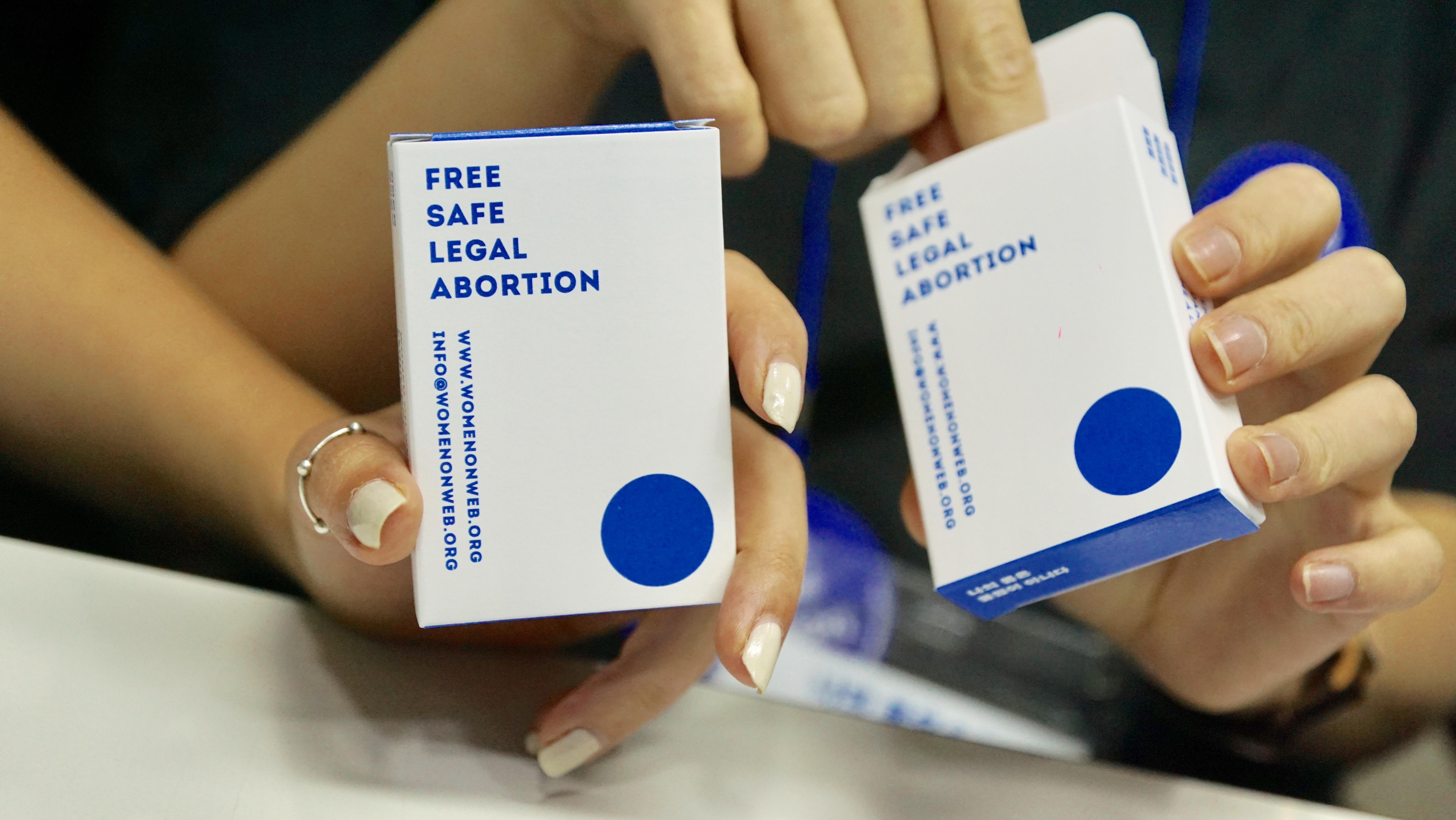  퍼포먼스에 사용된 약상자를 들고 찍은 사진. 약상자에 무료이고 안전하고 합법인 임신 중단 (free, safe, legal abortion)이라고 쓰여있다.