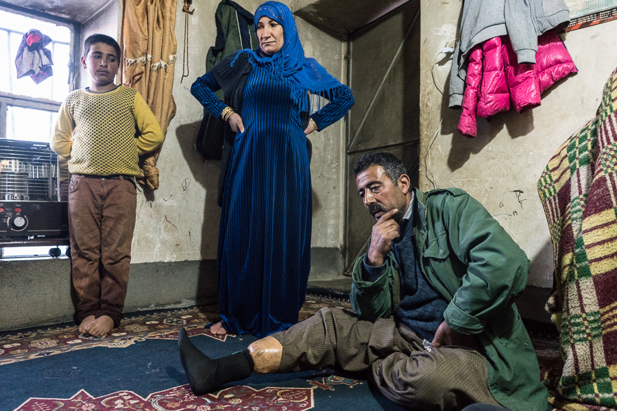 Village de Shene, Kurdistan, Irak. F&eacute;vrier 2017. Apo, apr&egrave;s avoir servi dans les peshmergas, travaillait comme karwanji. Kurde d'Irak, il n'avait pas d'autorisation. Un soir de printemps en 2003, alors qu'il transportait du sucre en Iran, une patrouille de soldats menace de l'arr&ecirc;ter si ils le revoient. Avec son camarade, ils d&eacute;cident donc de prendre un autre chemin pour le retour. Il &eacute;tait aux alentours de 20h, et la nuit &eacute;tait noire quand soudainement une explosion a d&eacute;chiquet&eacute; sa jambe. Quand je suis tomb&eacute; au sol, ma main s&rsquo;est pos&eacute;e sur une autre mine. A ce moment l&agrave;, j&rsquo;ai voulu mourir, exploser la deuxi&egrave;me mine et en finir. Puis j&rsquo;ai pens&eacute; &agrave; mes 5 enfants, et j&rsquo;ai voulu rester en vie pour eux. Je me suis dit que Dieu m&rsquo;aiderait. La personne qui &eacute;tait avec moi a &eacute;t&eacute; bless&eacute;e l&eacute;g&egrave;rement. Il a band&eacute; ma jambe avec un keffieh. Nous avons cri&eacute; pour appeler &agrave; l&rsquo;aide, des gens sont arriv&eacute;s. Ils nous ont emmen&eacute;s dans un village pr&egrave;s duquel se trouvait un camp du PKK. L&agrave;, ils m&rsquo;ont soign&eacute;, fait un bandage et envoy&eacute; dans un hopital. Puis j'ai &eacute;t&eacute; transf&eacute;r&eacute; &agrave; Sulaymaniyeh, o&ugrave; j&rsquo;ai du &ecirc;tre amput&eacute; deux fois. On m&rsquo;a mis une proth&egrave;se. Mais je vais devoir subir une nouvelle amputation car ma jambe redevient noire. Personne ne travaille dans la famille, mon fils plus &acirc;g&eacute; est &eacute;tudiant. Comme j&rsquo;&eacute;tais peshmerga, j&rsquo;ai une allocation du gouvernement vers&eacute;e tous les trois mois, de 1 200 000 IQ, mais elle va se r&eacute;duire.