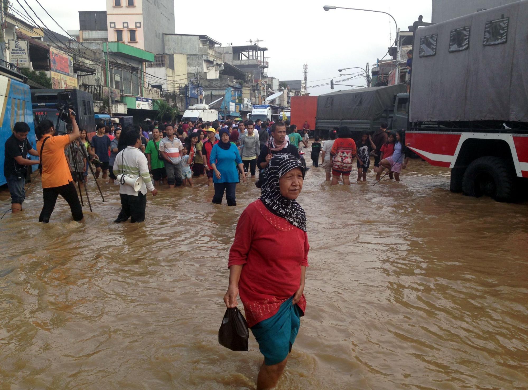 Jakarta residents navigate severe monsoon flooding in the Special Capital District of Indonesia.