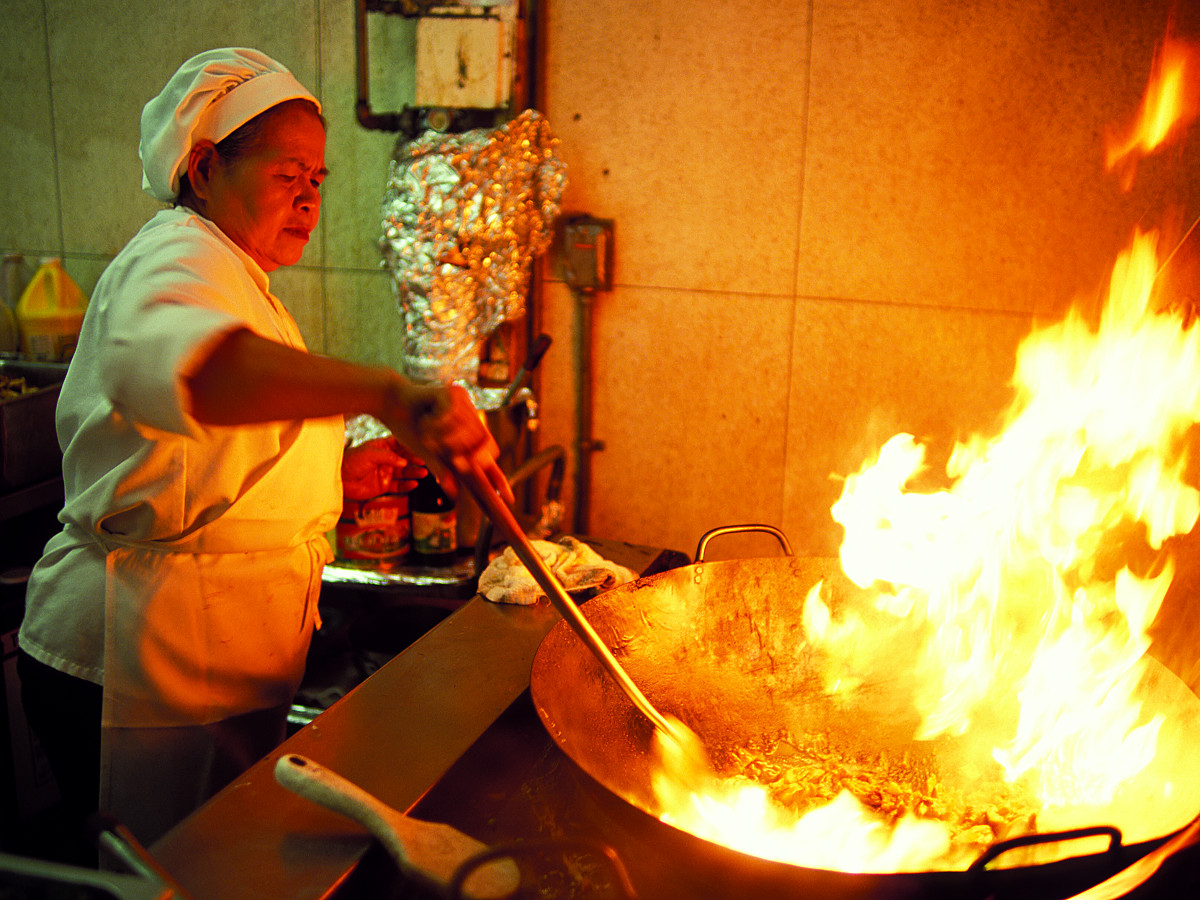 A worker makes Pad Thai in the cafeteria kitchen at Pasadena City College in Pasadena, California, on October 23, 2003. Ho-Yen Tsang—PCC Courier