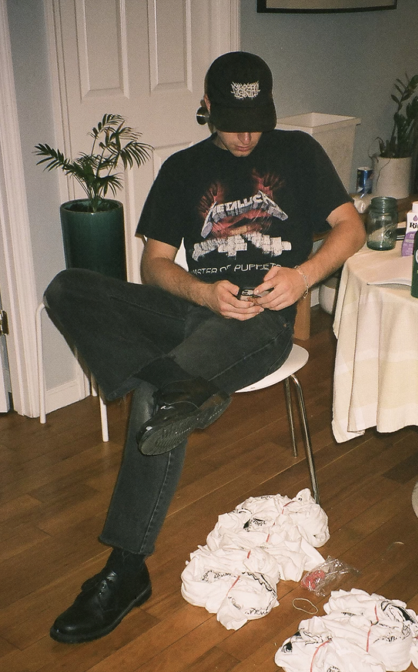 A man texting on an iphone wearing black