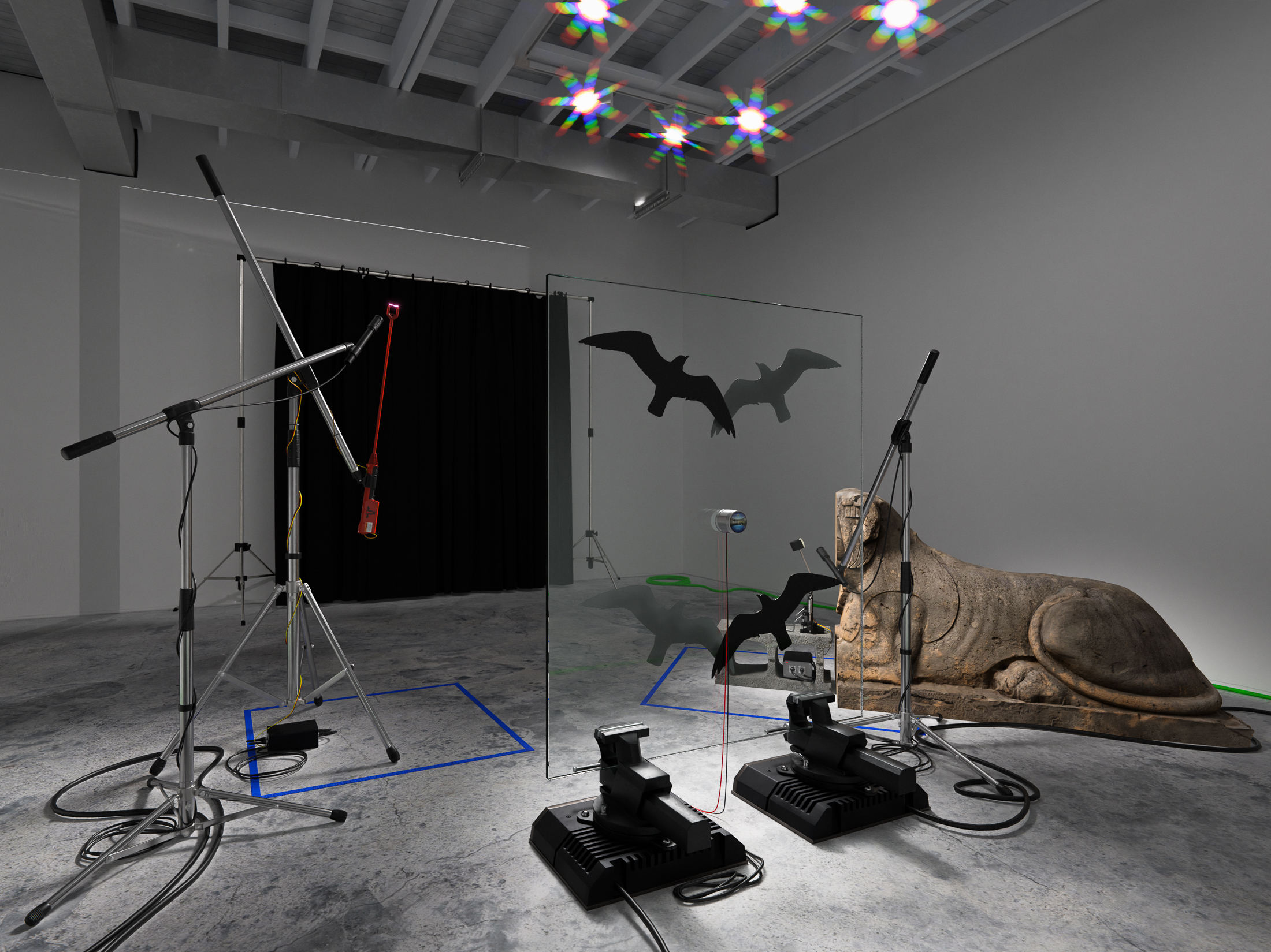 Beasts without number, 2022, defaced garden statue, cattle prod, transducer mic, kick drum pedal, servo motor, car amplifiers, cinderblock, vises, glass, anti-collision decals, arduino controllers, mics, mic stands, faux rock speakers, cables, tape, dimensions variable