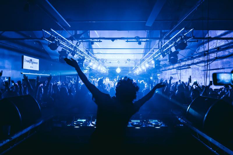 Annie Mac performing at Banana Block in Belfast for her Before Midnight show, surrounded by an energetic crowd under blue lighting.
