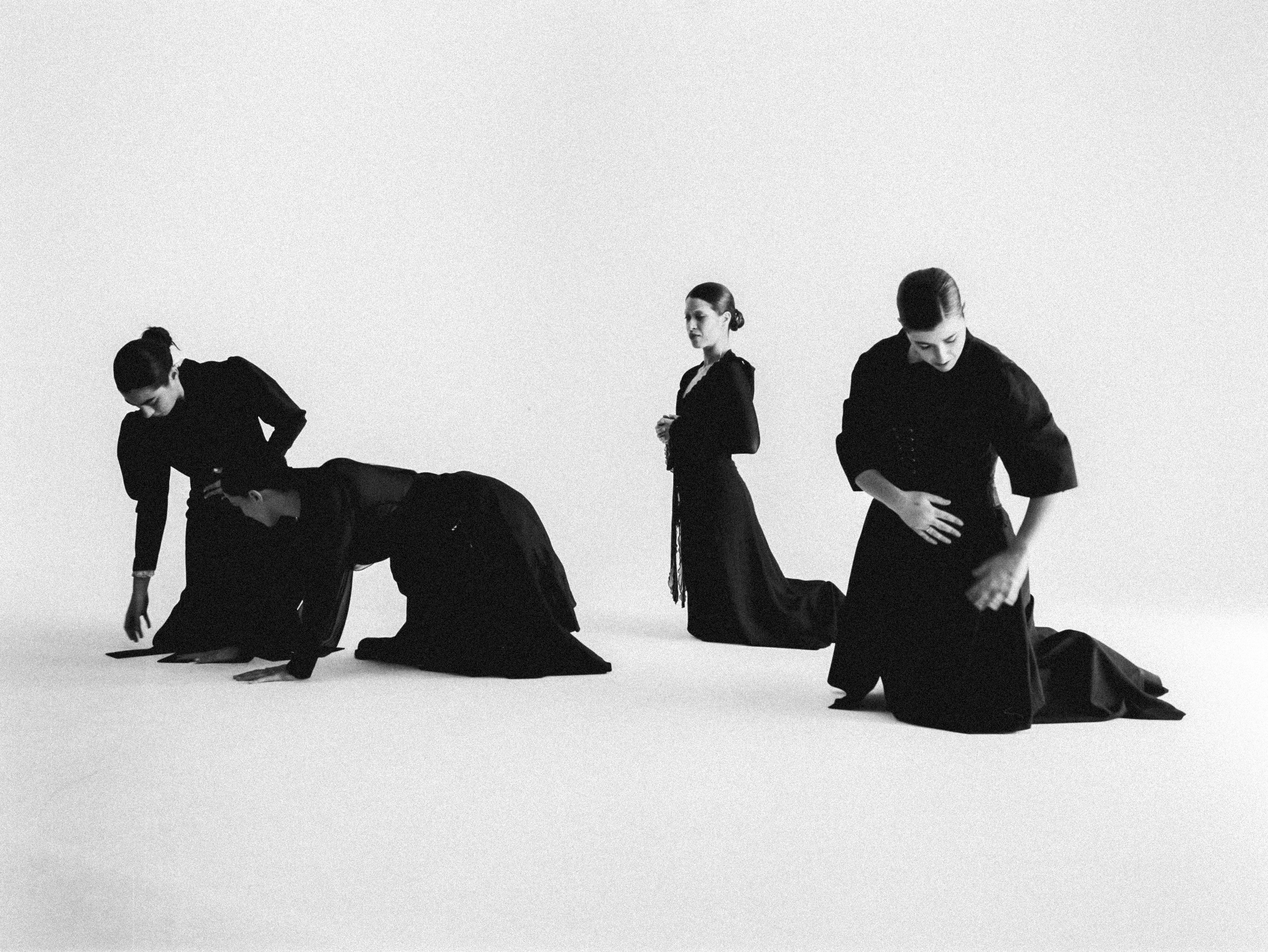 Black and White Picture of Five Women Kneeling Down on White Background