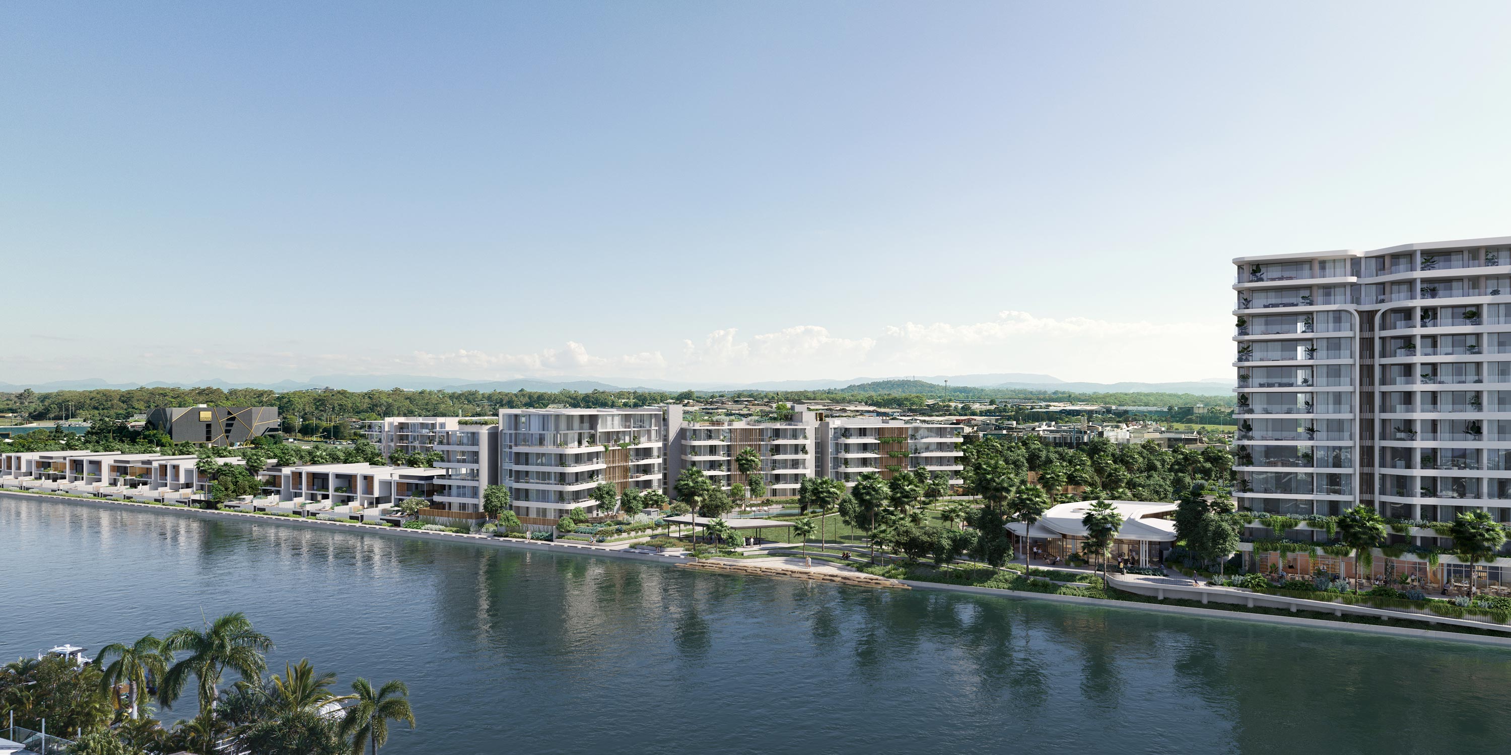 Aerial view of contemporary waterfront mixed use development with lush landscaping and recreation opportunities.