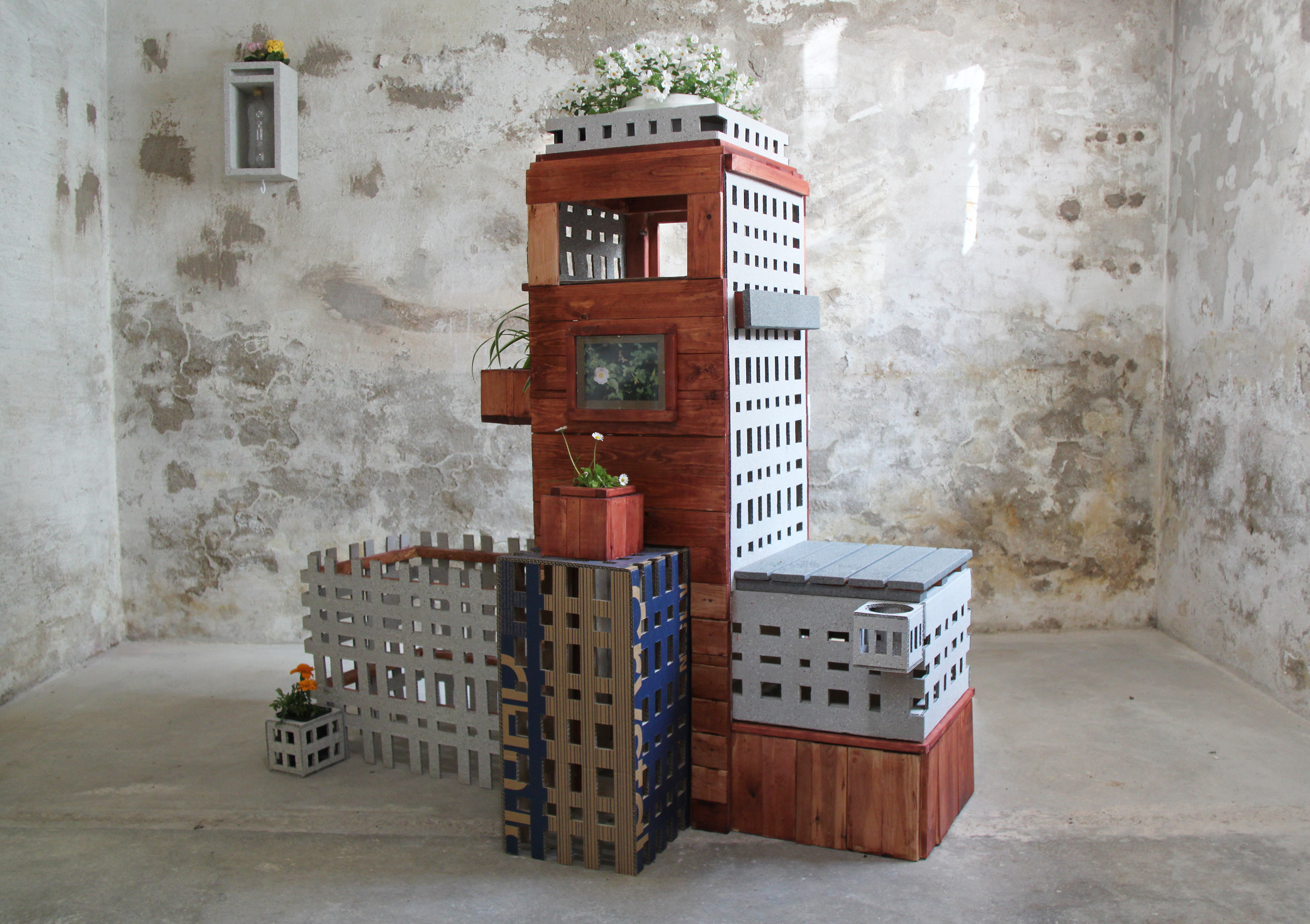 the plaza, 2025, 136cm x 135cm x 94cm, cardboard, wood, wood stain, stone textured spray paint, plants, styrofaom, framed image, soil