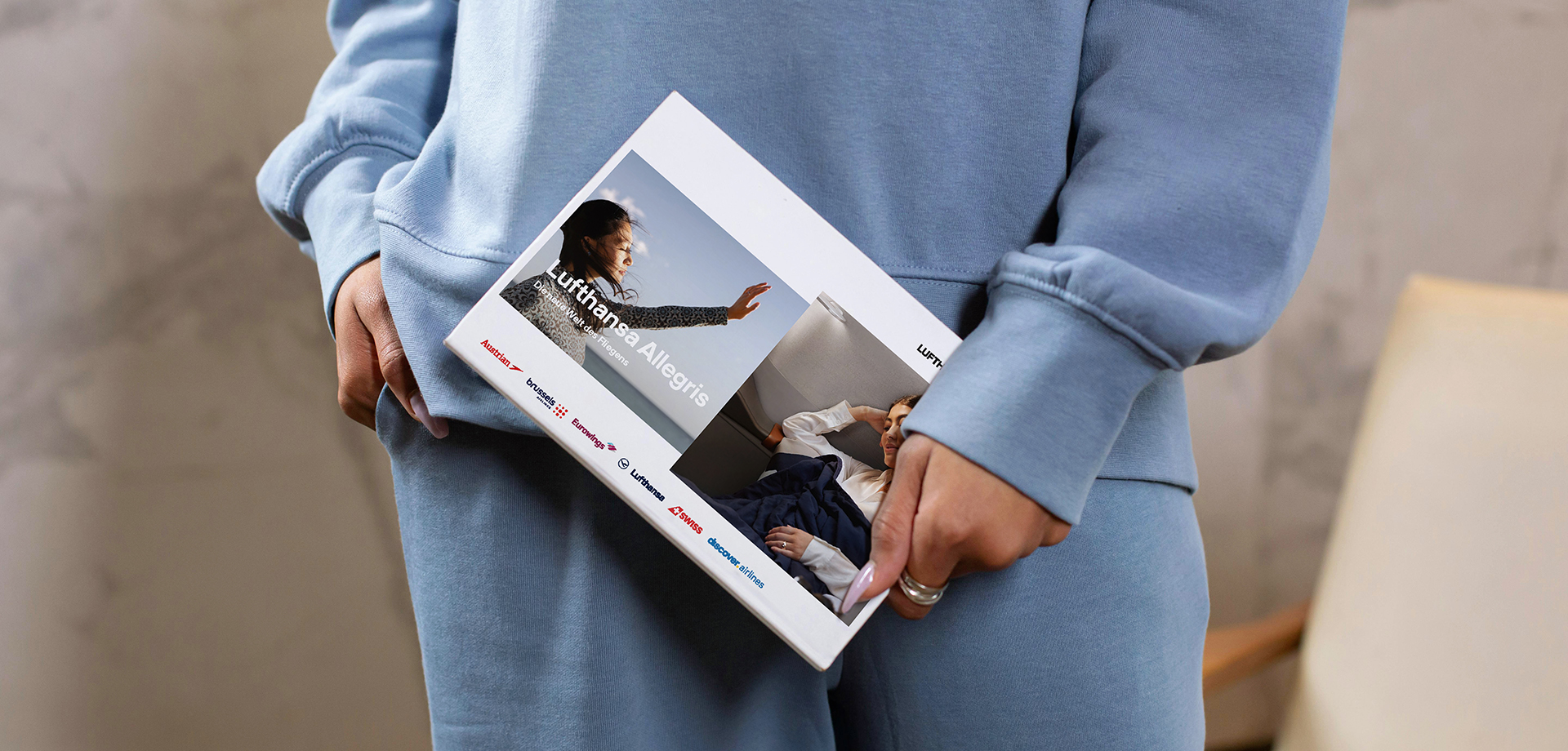 An elegant woman holding the Allegris leaflet in her hand, showcasing the key visual of the campaign