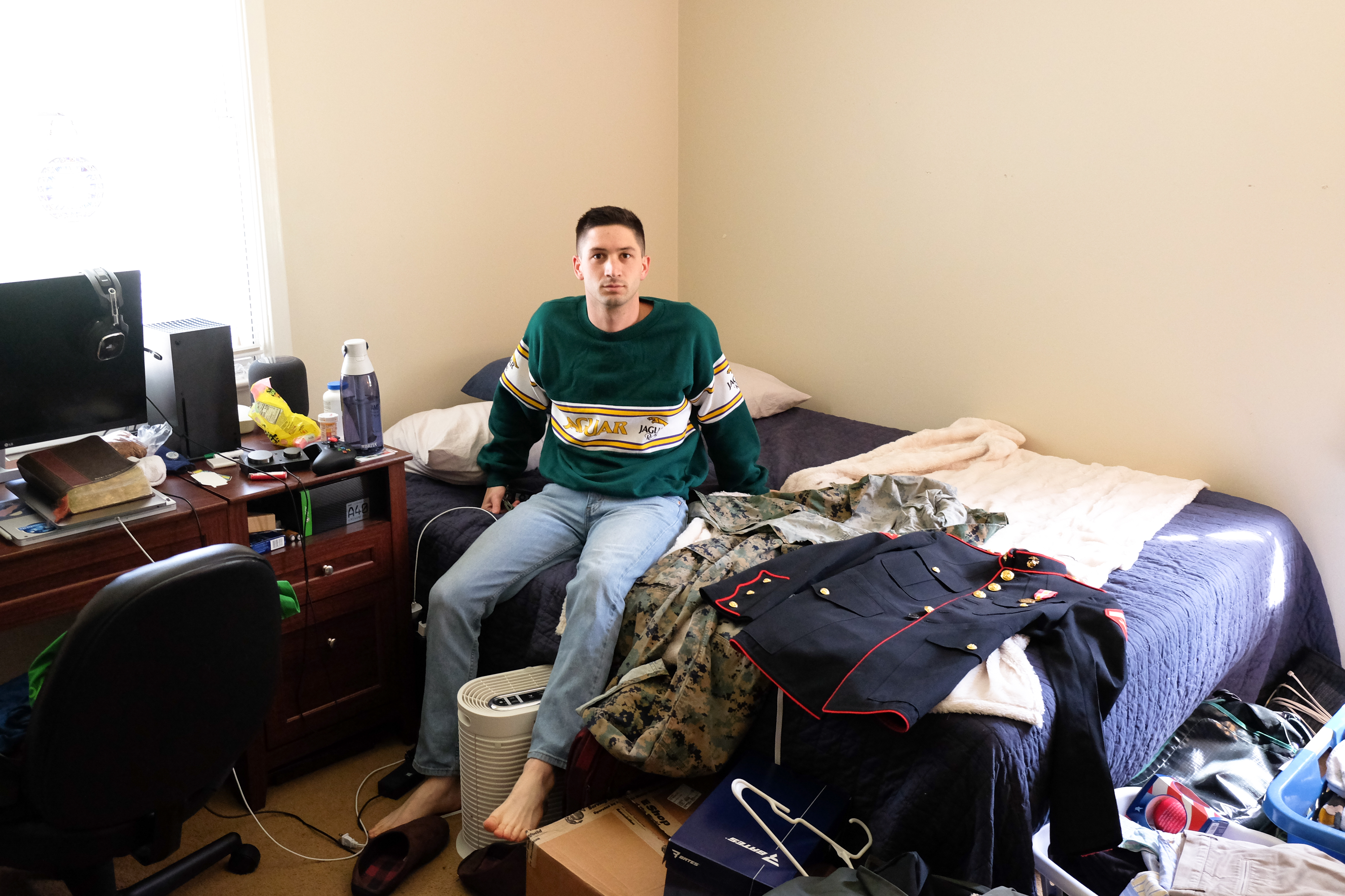 Blake, 22, sits next to his Marine Corps uniform in Baton Rouge, LA.